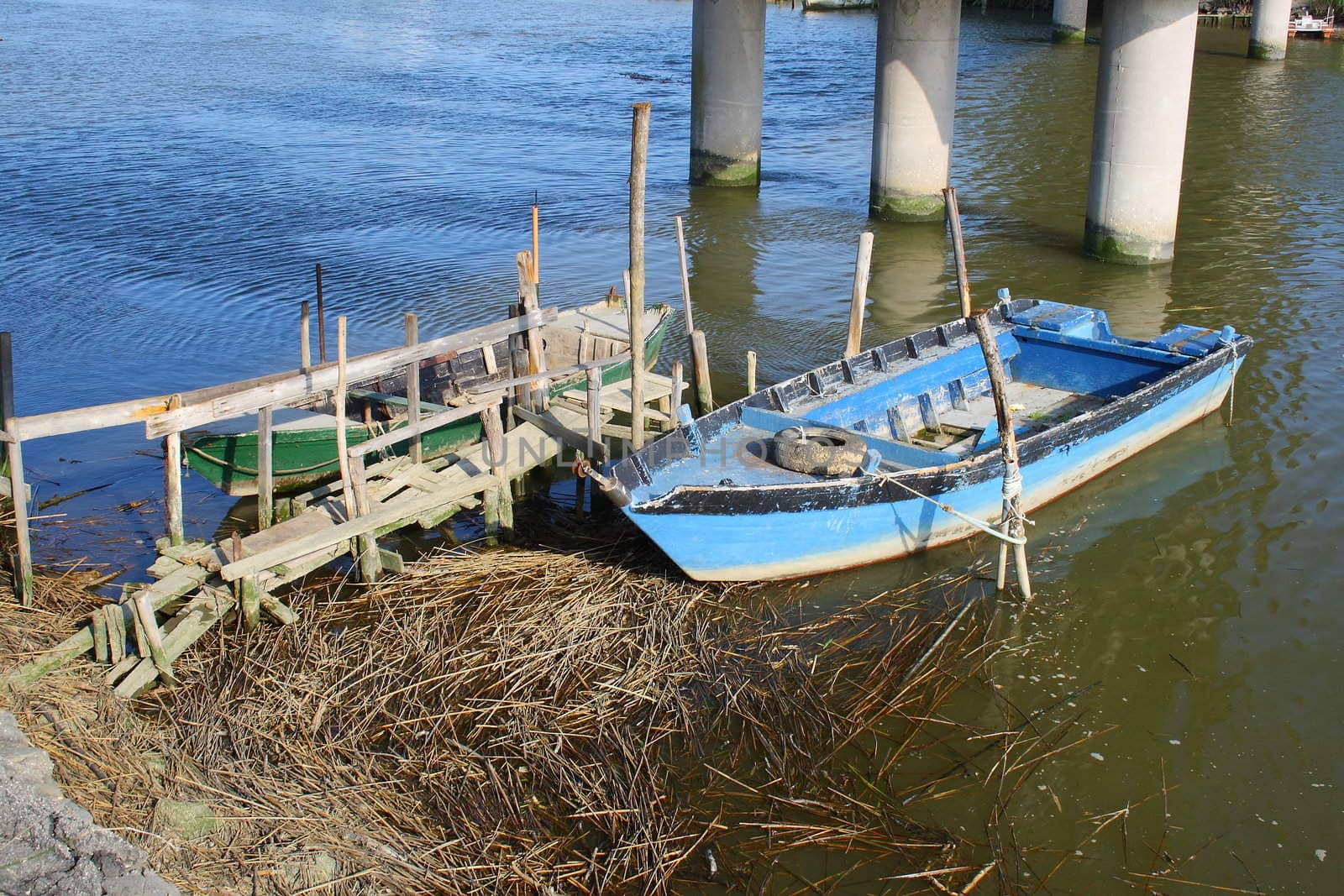blue and wooden rowboat parked in a river