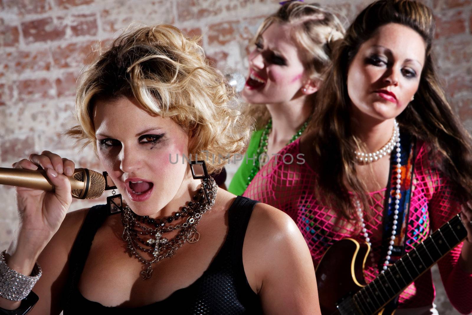 All-girl punk rock band performs in front of a brick background