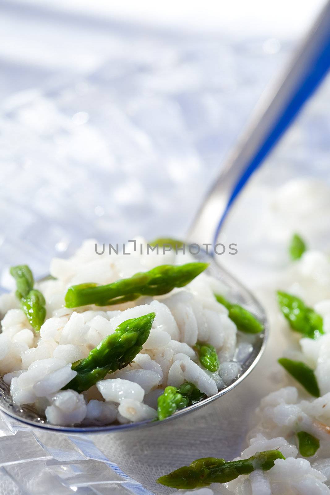 Boiled rice with green asparagus on spoon