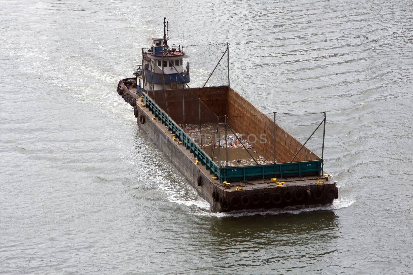 Empty boat for transporting garbage cruising in a river, used for waste management
