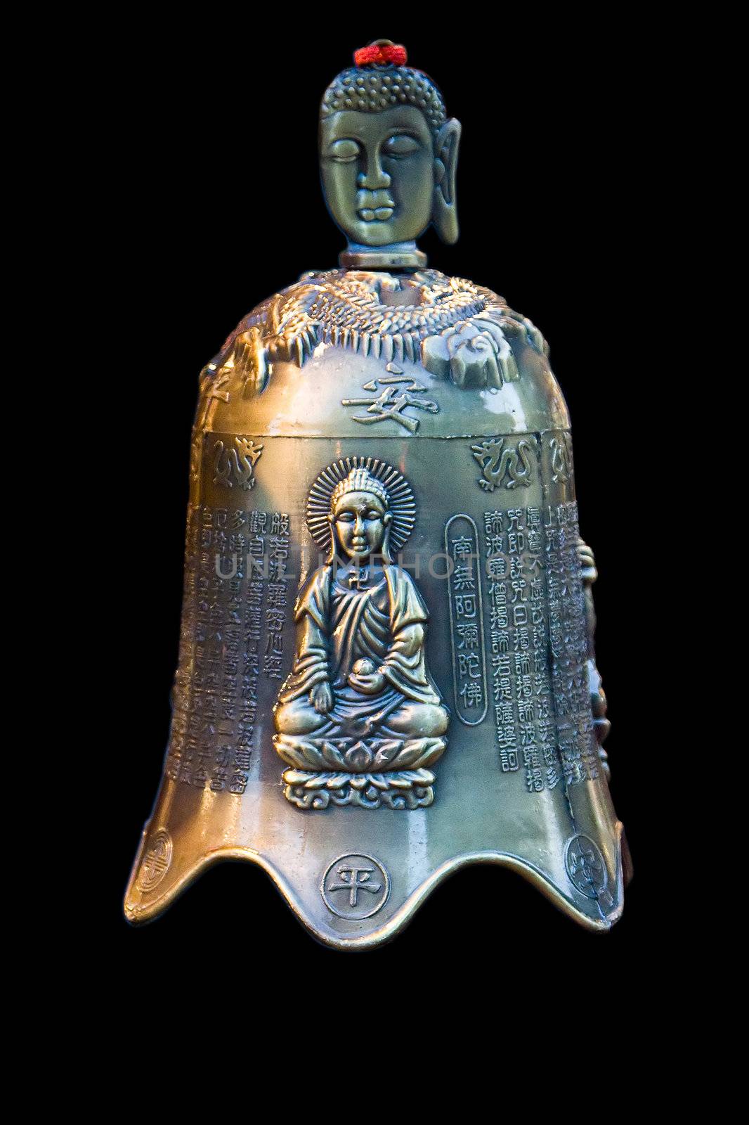 A bronze bell with Chinese characters and an image of Buddha sitting in the lotus position and the face of Buddha as handle, isolated on black