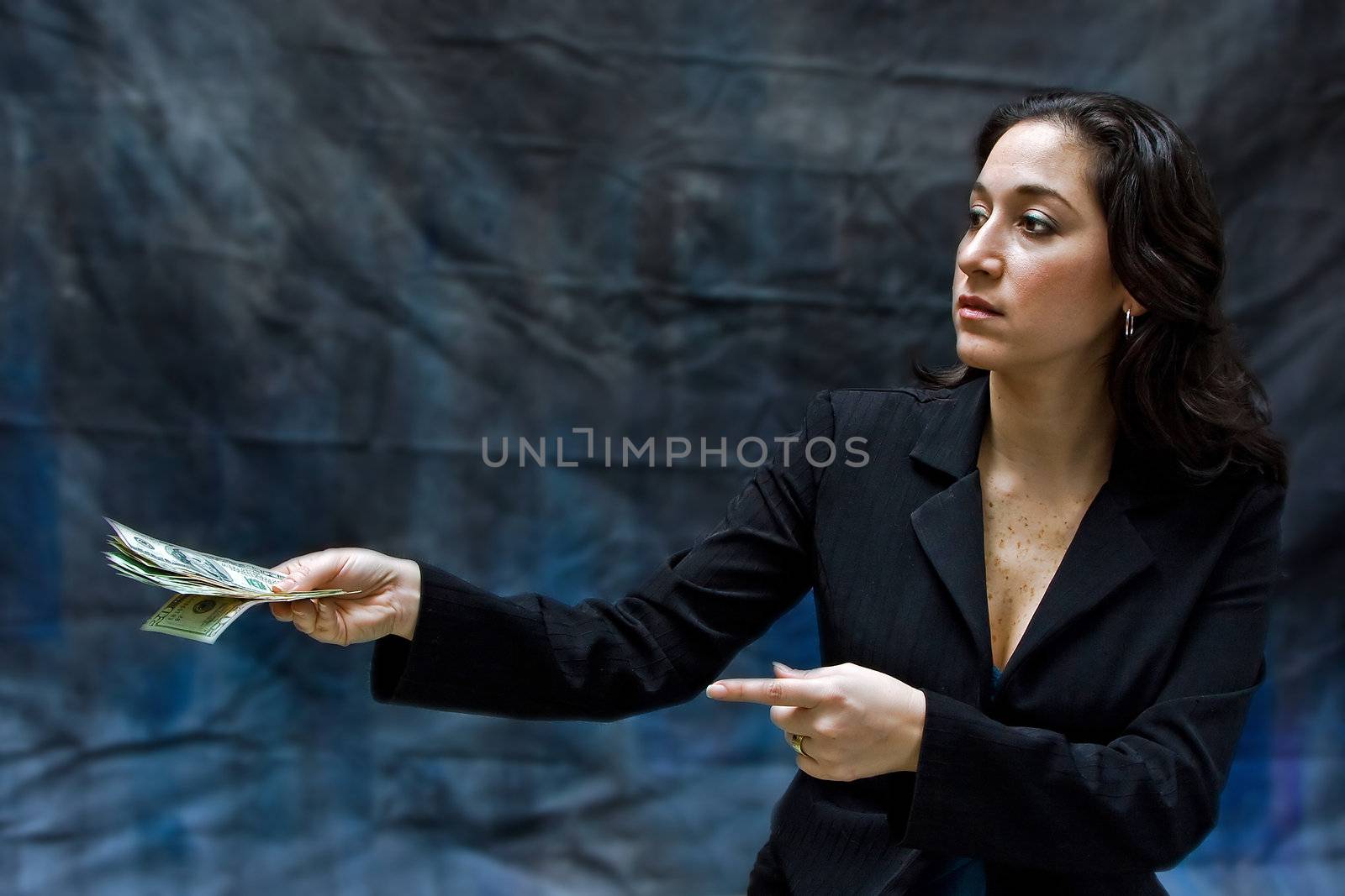 Business woman giving money and pointing, isolated on a dark background