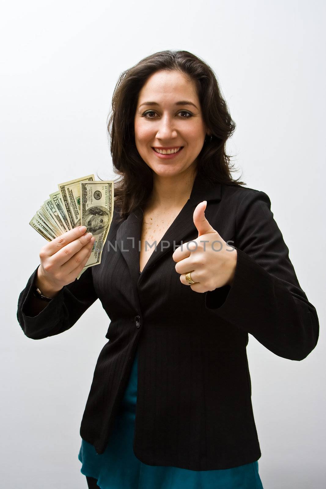 Smiling business woman holding up fanned money and a thumb up, isolated on white