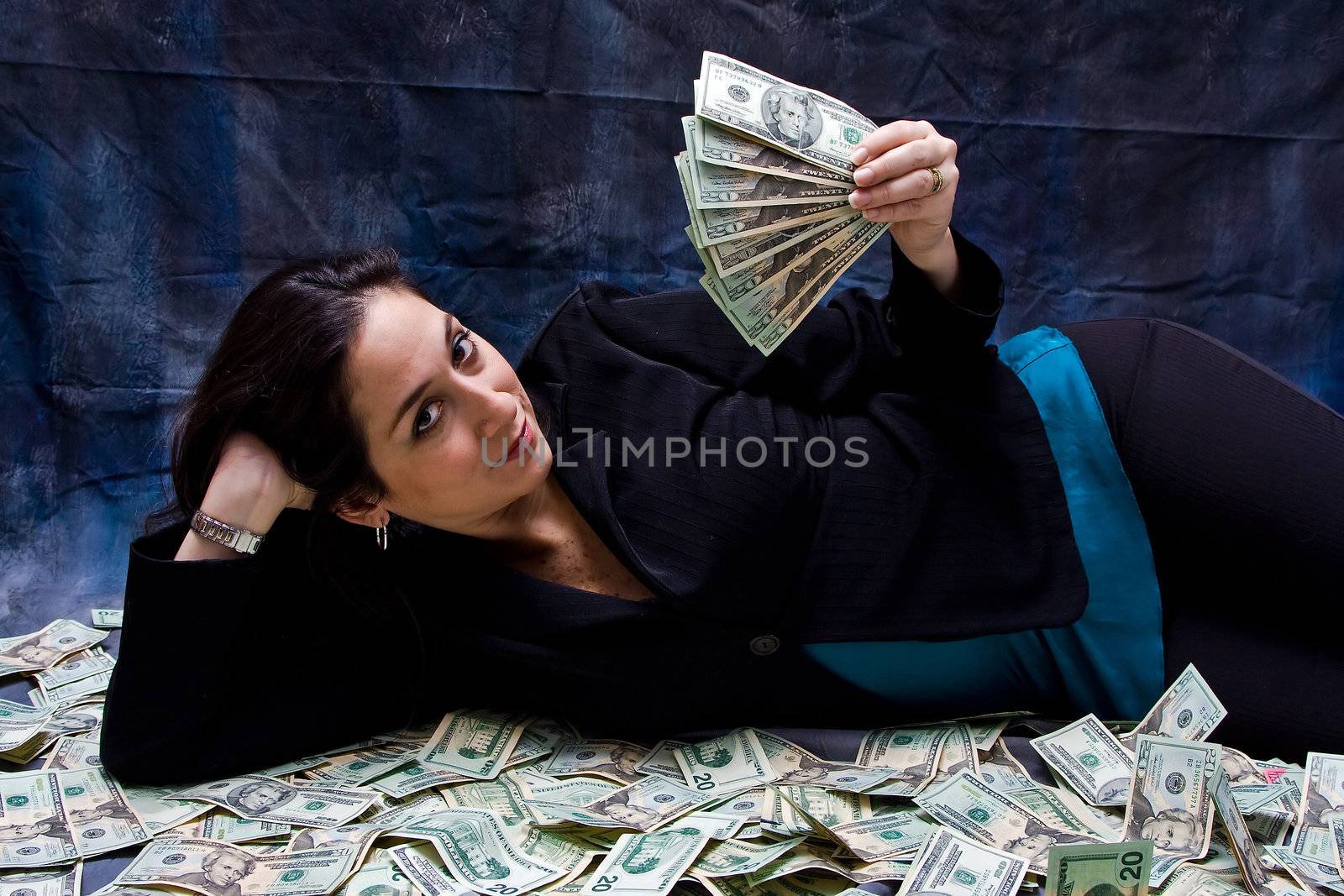 Rich business woman waving money and laying with her money isolated on a dark background