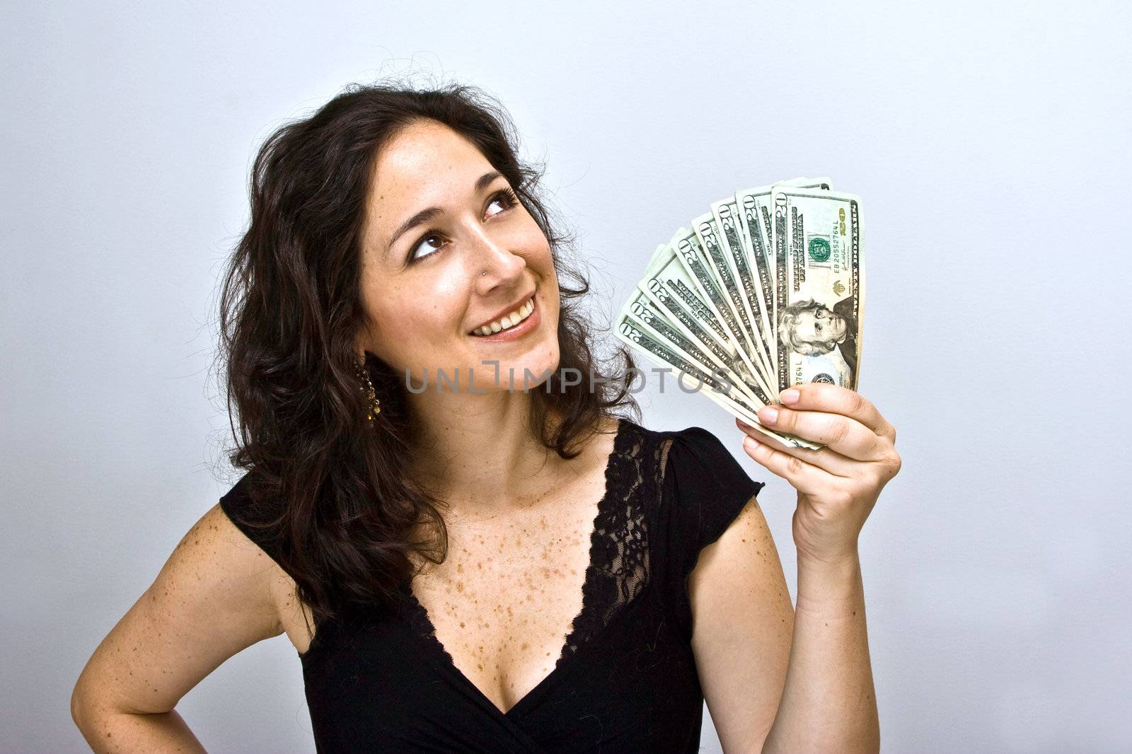 Woman waving money and looking up, on a white background