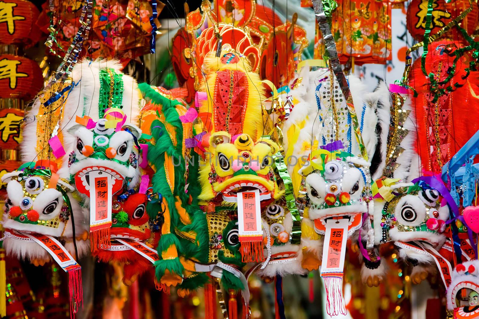 Colorfull Chinese lunar new year's dragons hanging in front of a store with good fortune quotes.