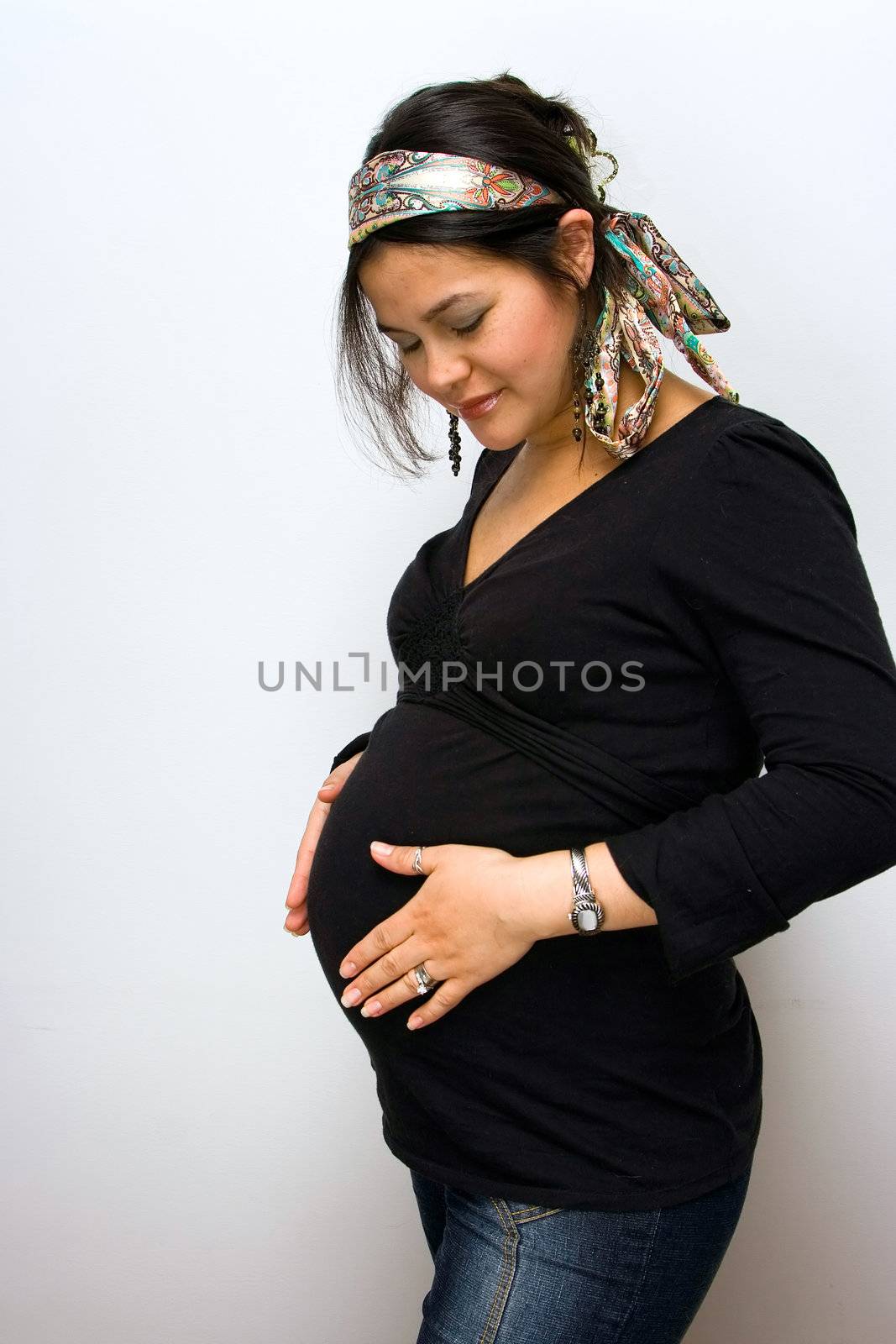 A pregnant woman is touching her belly to feel her baby's movement.