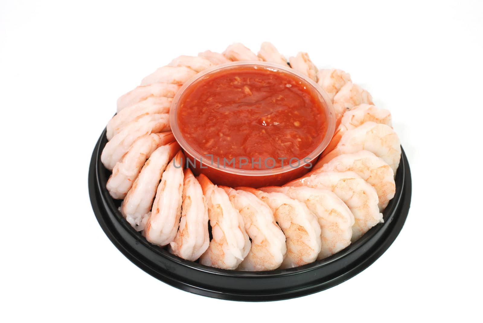 Shrimp cocktail arranged around a cup of seafood sauce.  Isolated on white background.