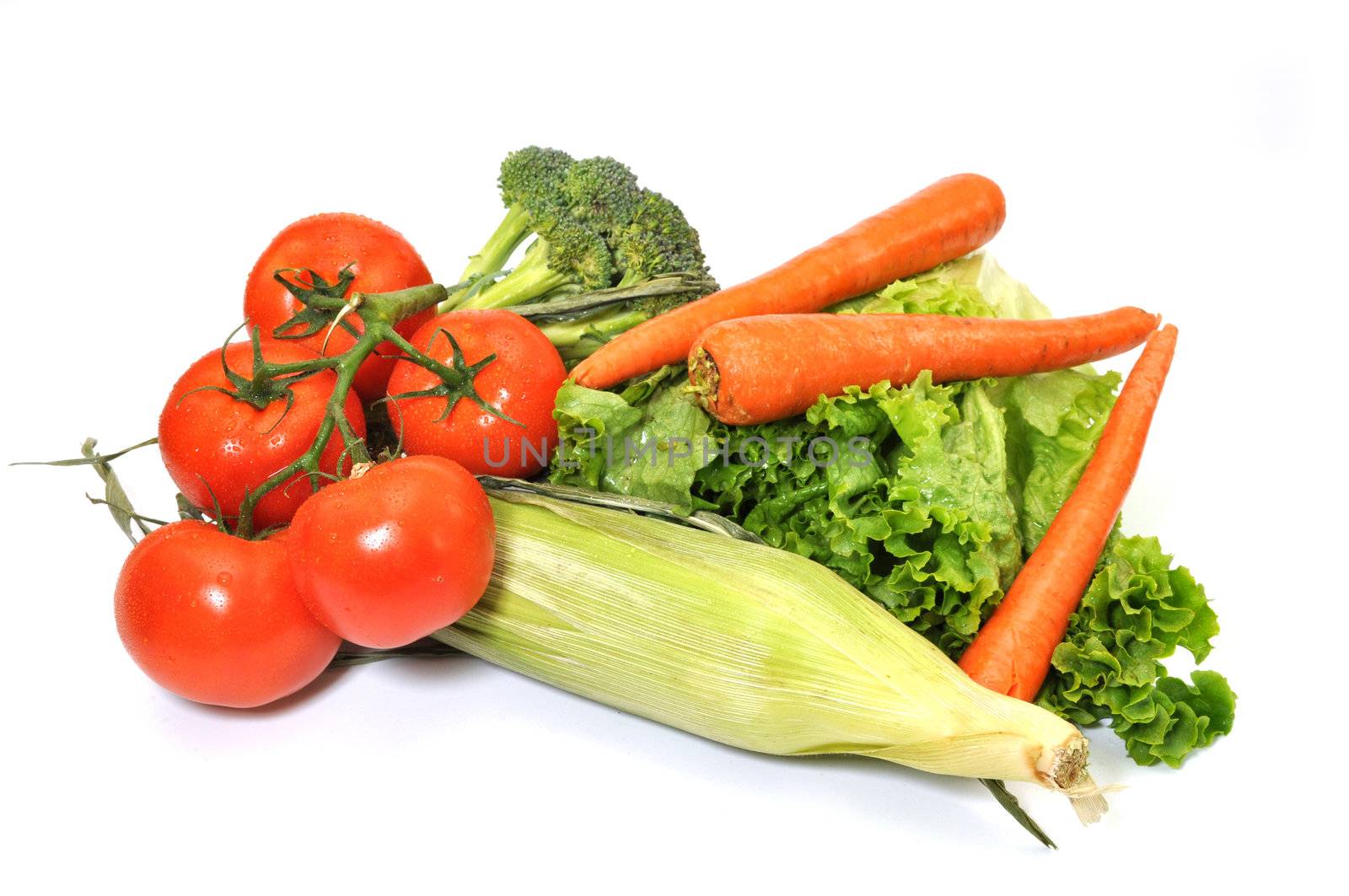 Green leafy lettuce, tomatoes, broccoli, carrots, and corn isolated on white background.