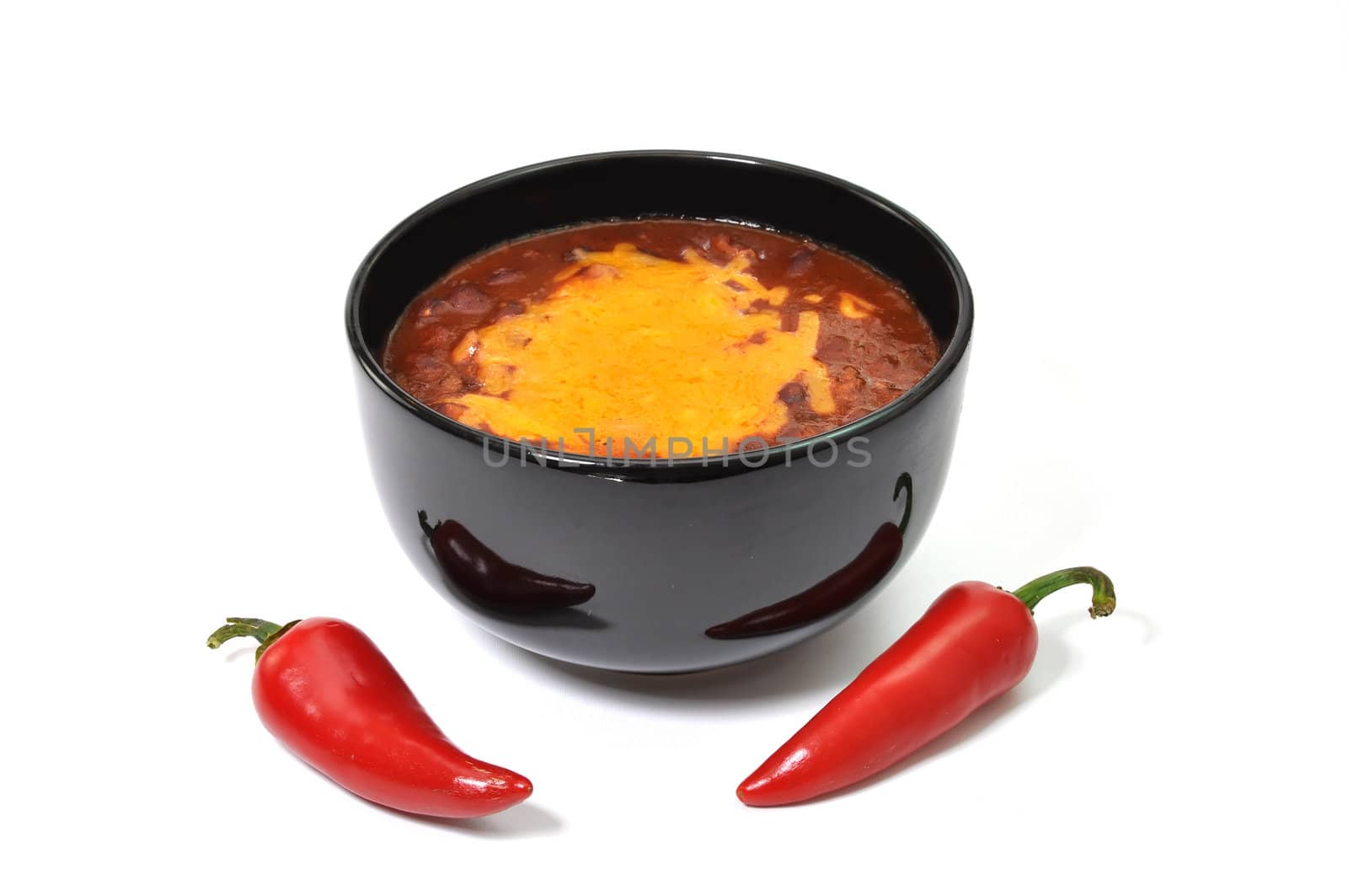 Bowl of chili with melted cheese and red cayenne peppers.  Isolated on white background.