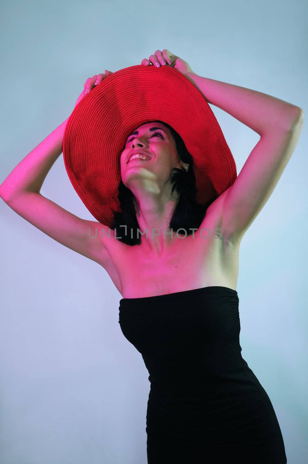 Portrait of young elegant woman wearing black dress and hat with happy expression