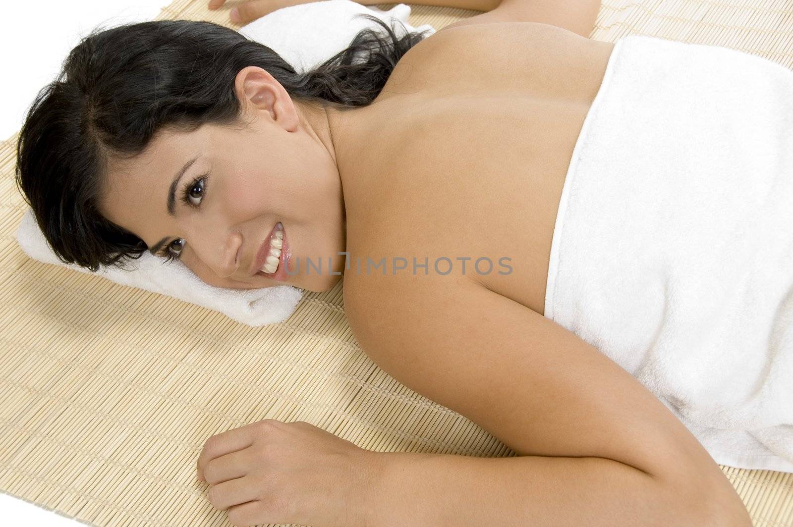 happy woman laying on bamboo mat by imagerymajestic