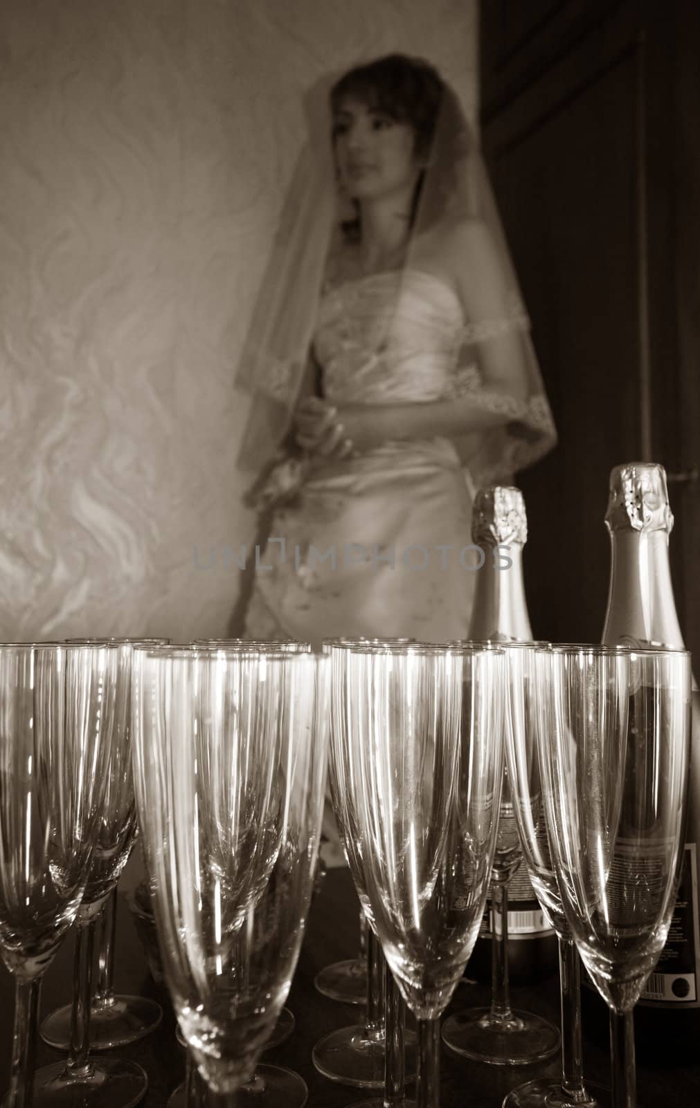 The worrying bride pending the groom on a background of glasses