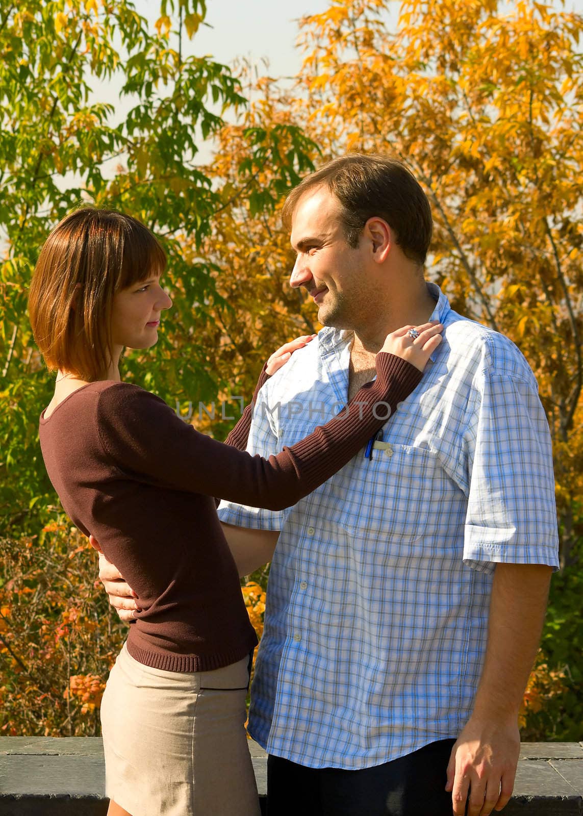 The beautiful girl and the young man in autumn park