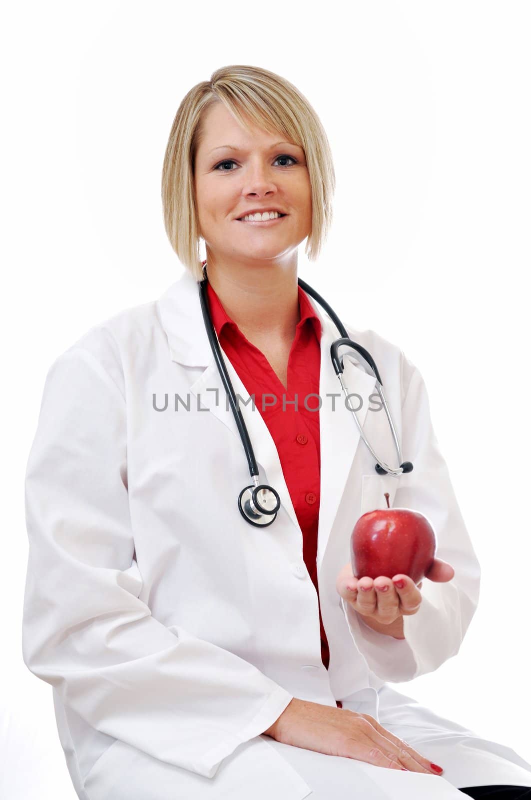 Female doctor holding apple with stethoscope isolated on white background.