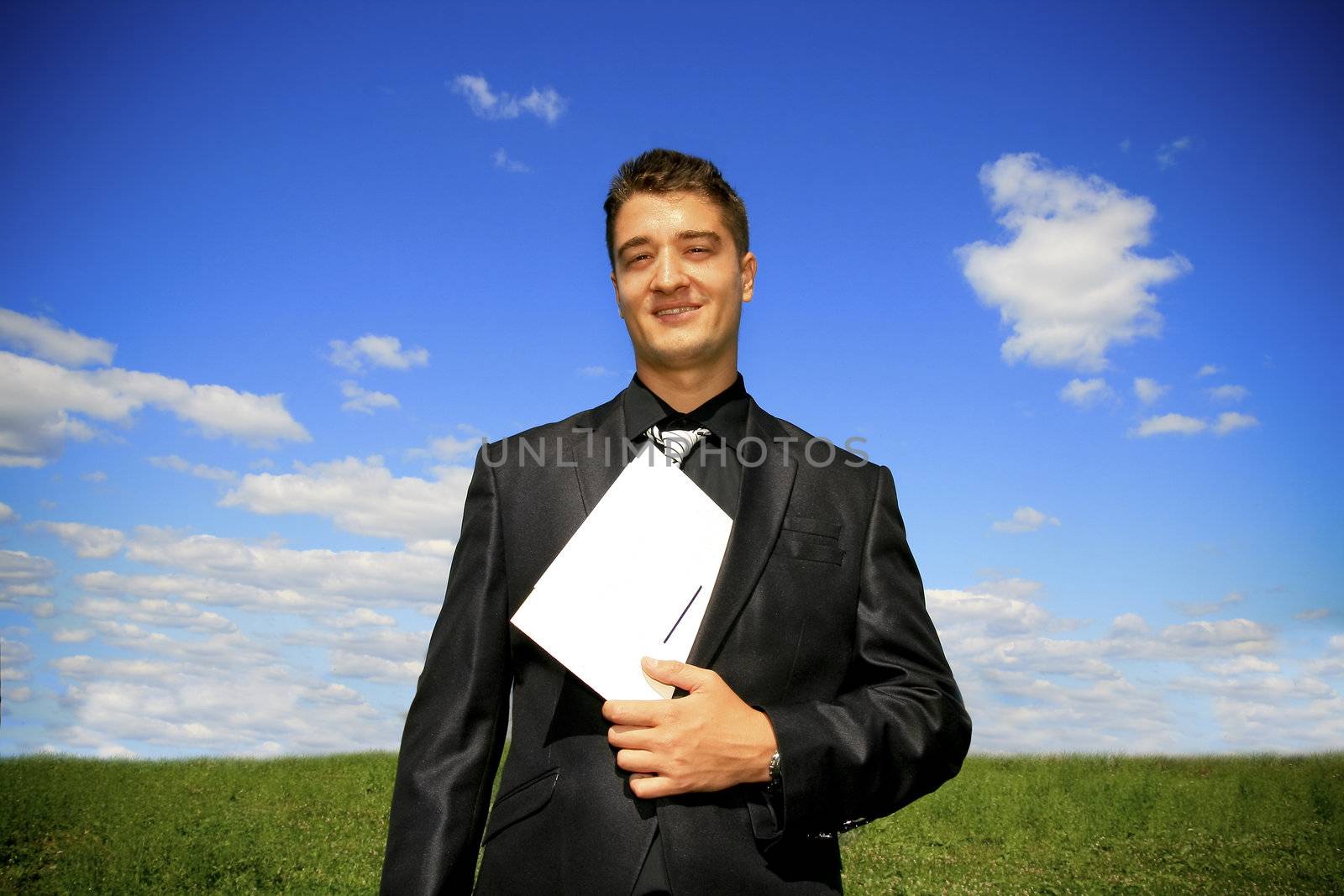Young businessman outdoor holding a folder.