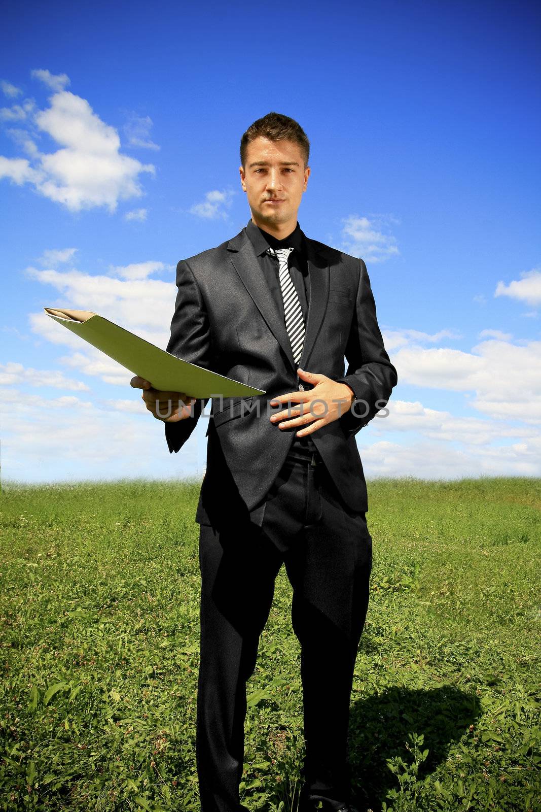 Man in black suit in the middle of the field