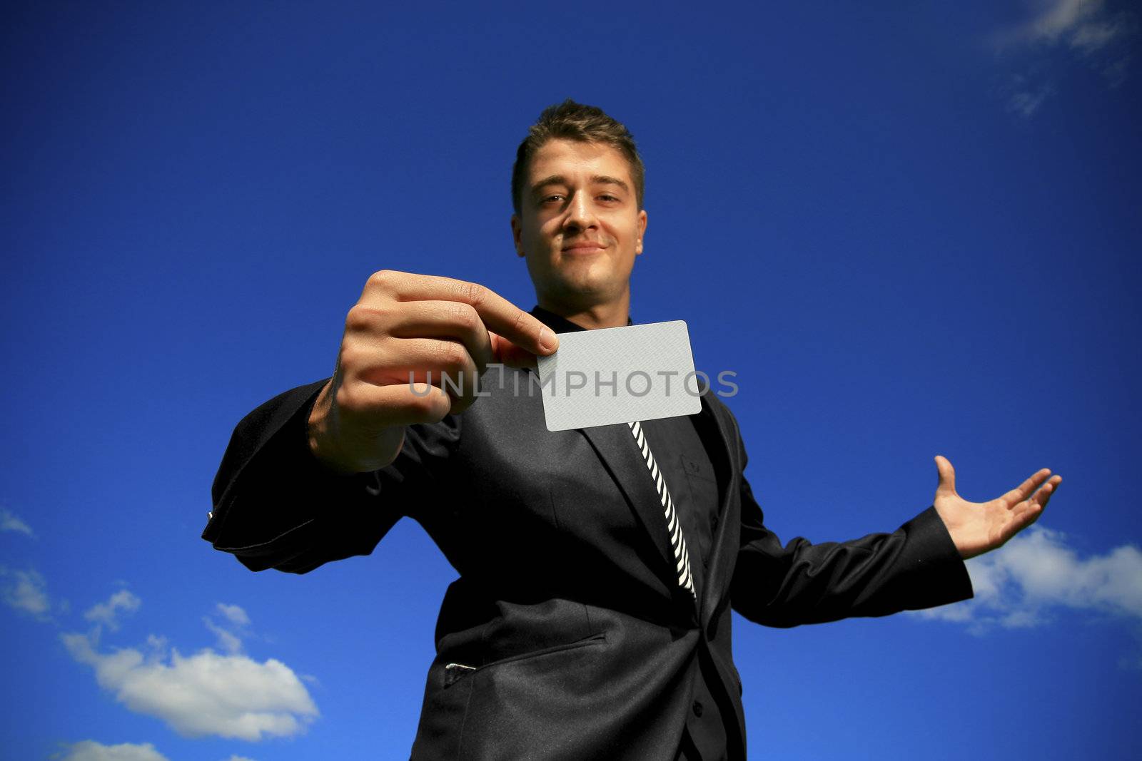 Slightly out of focus face of young man offering a focused card.