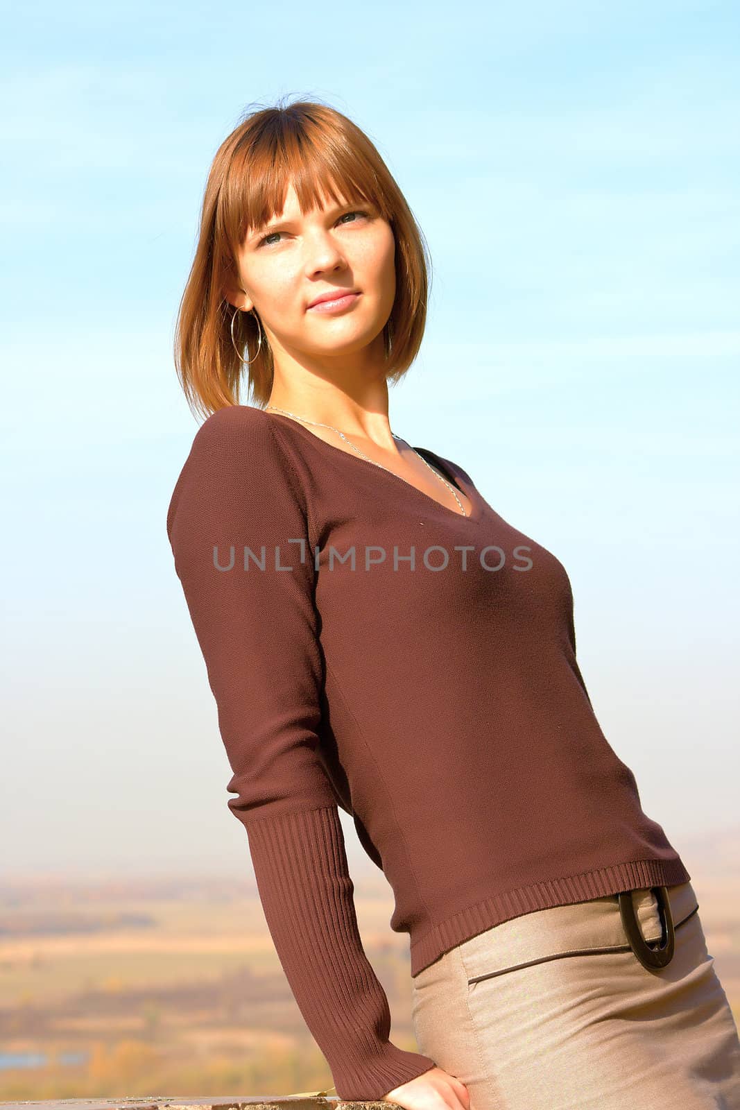 Portrait of the beautiful young girl against blue sky