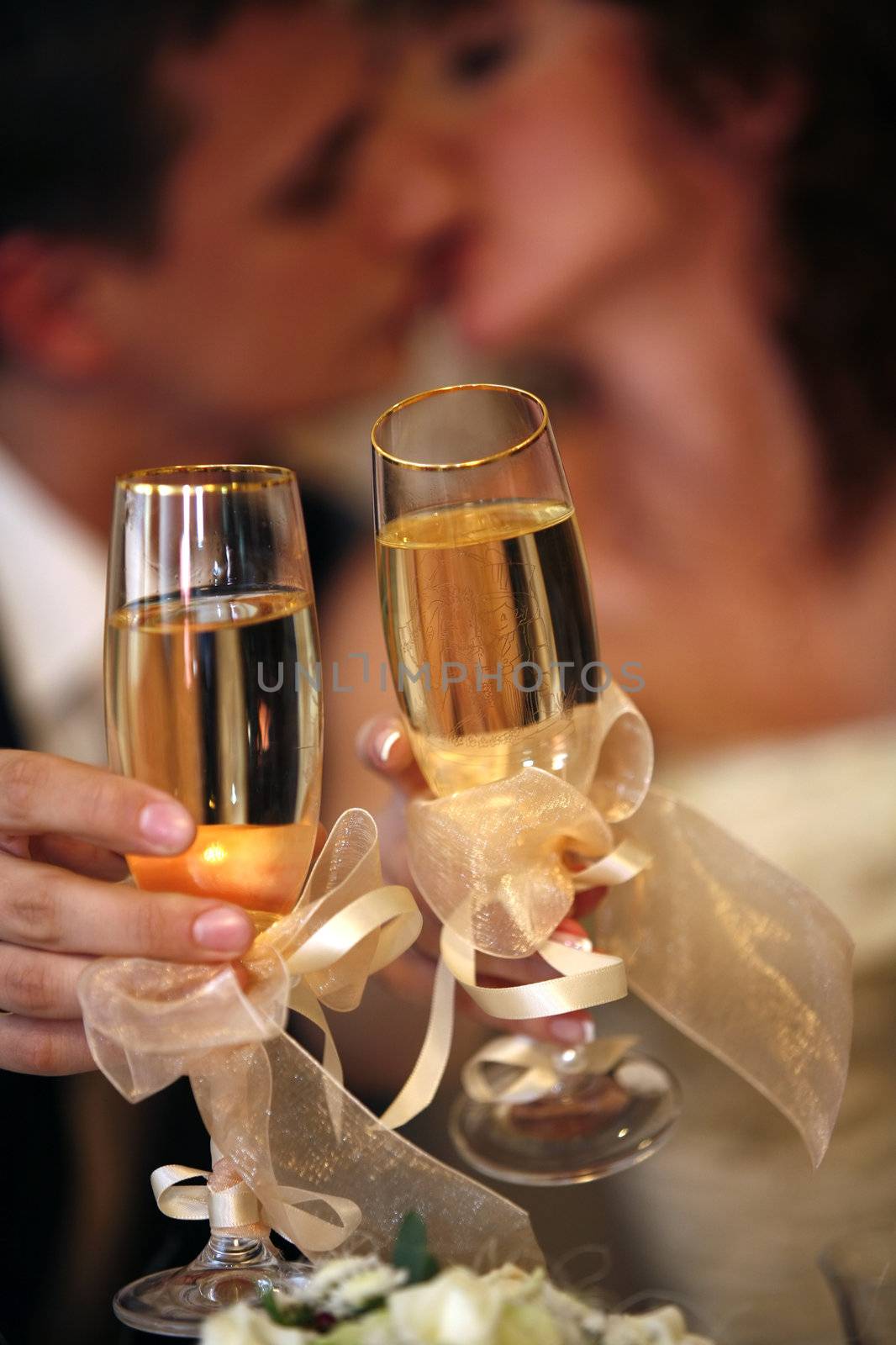 Glass of champagne in a hand of the groom and bride