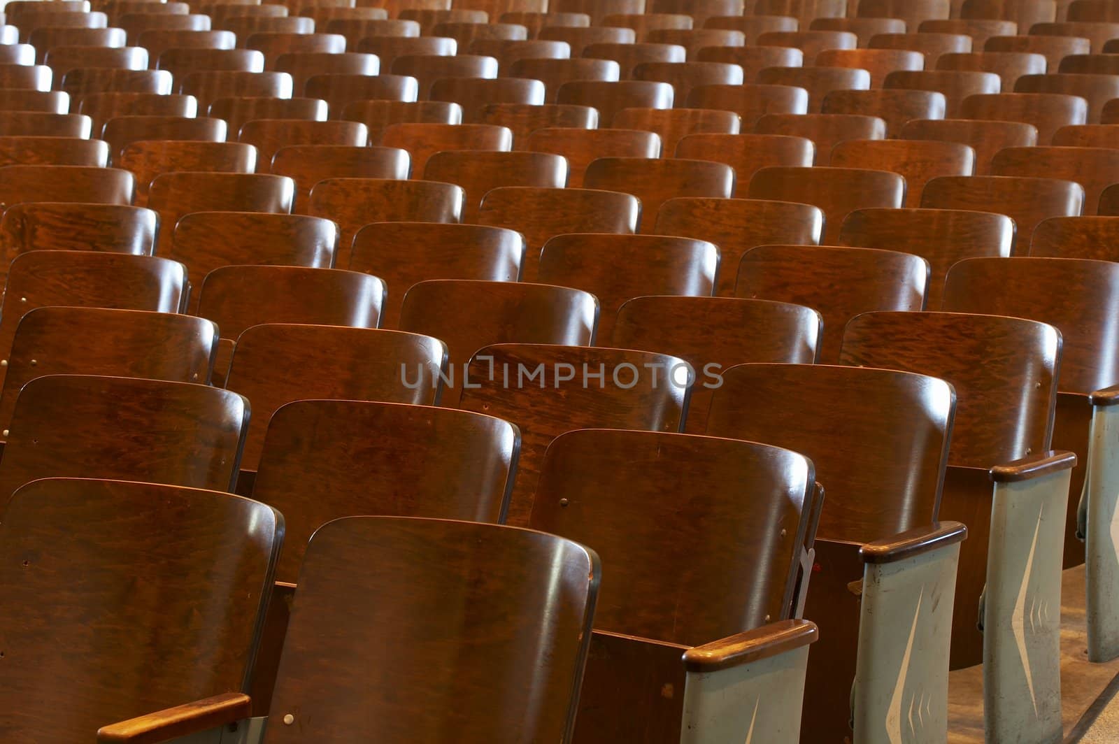 rows of wood chairs in an old auditorium