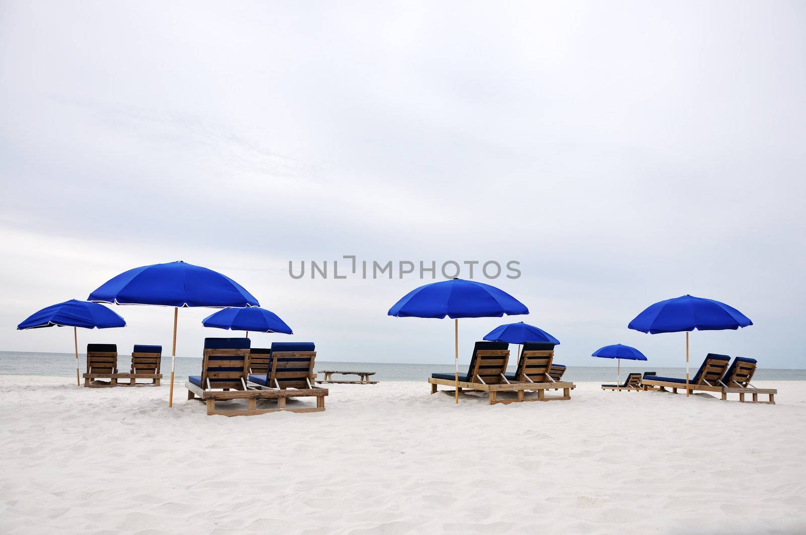Beach umbrellas and chairs on deserted beach.  