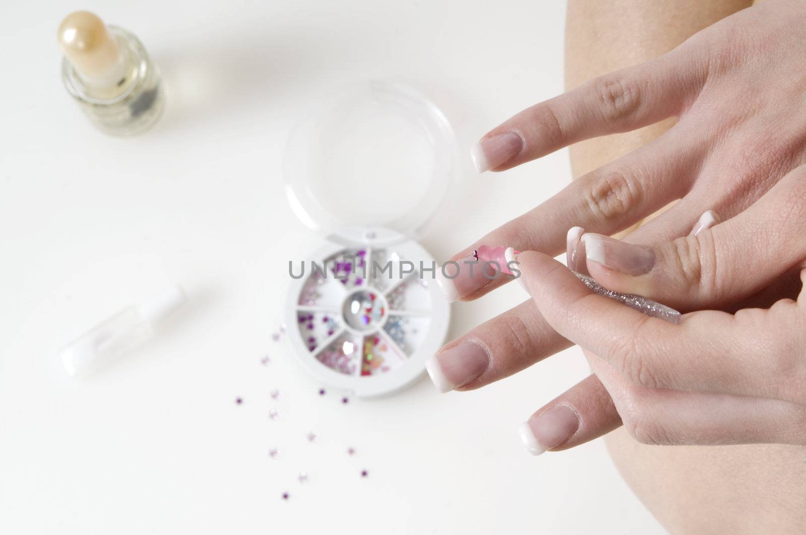 young woman painting her finger nails in a sort of nail art