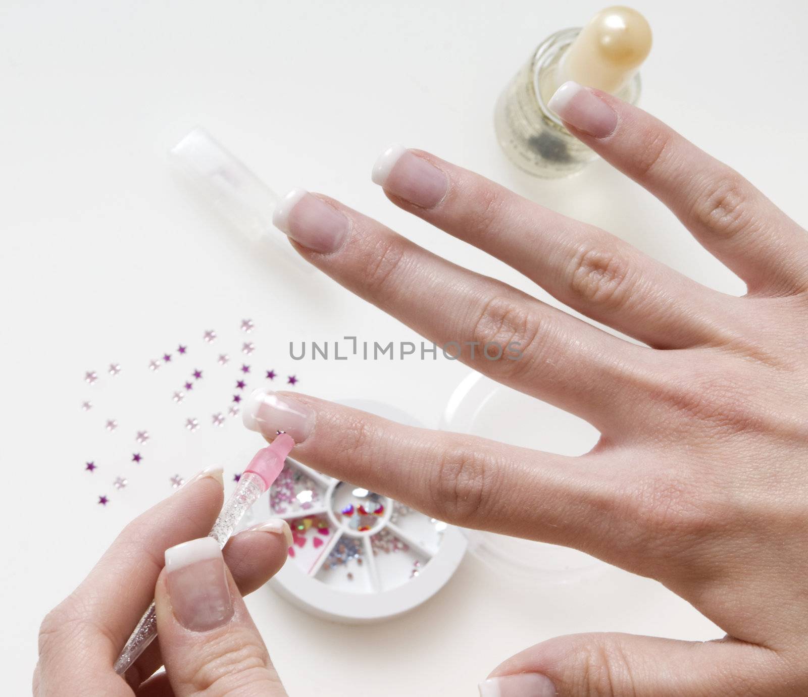 young woman painting her finger nails in a sort of nail art