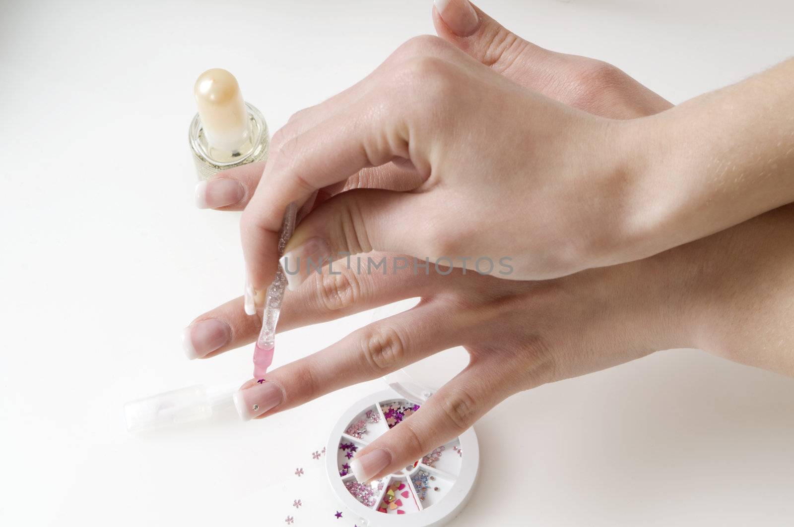 young woman painting her finger nails in a sort of nail art