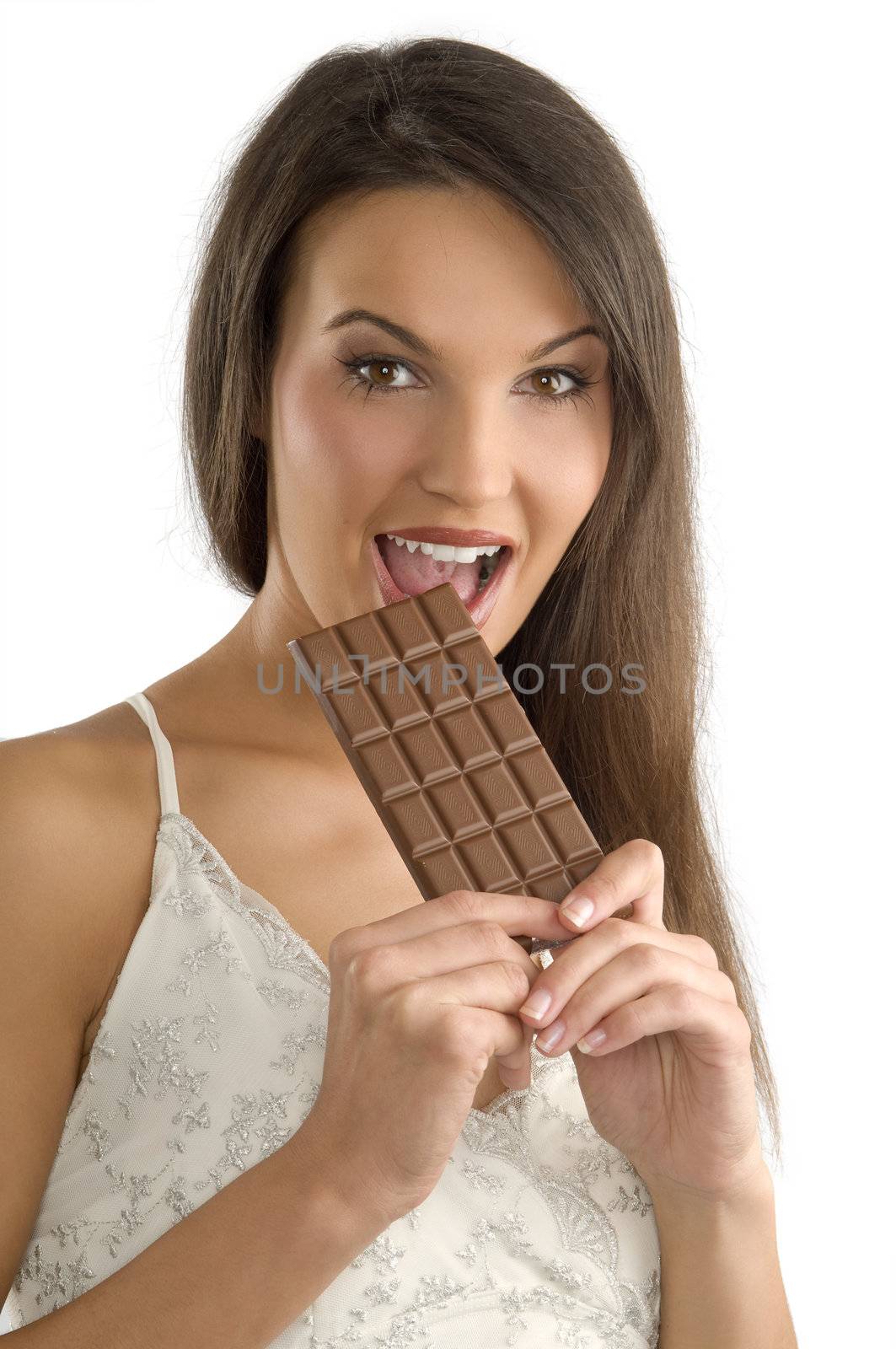 pretty young brunette wearing a white dress giving a bite to a block of chocolate