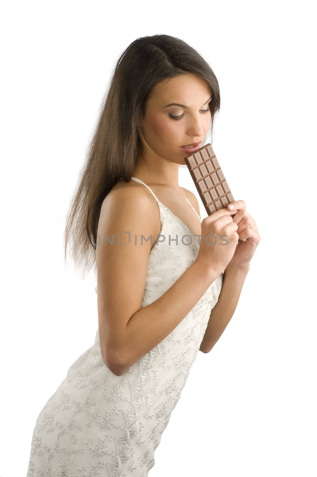 sensual brunette with long hair eating a block of chocolate