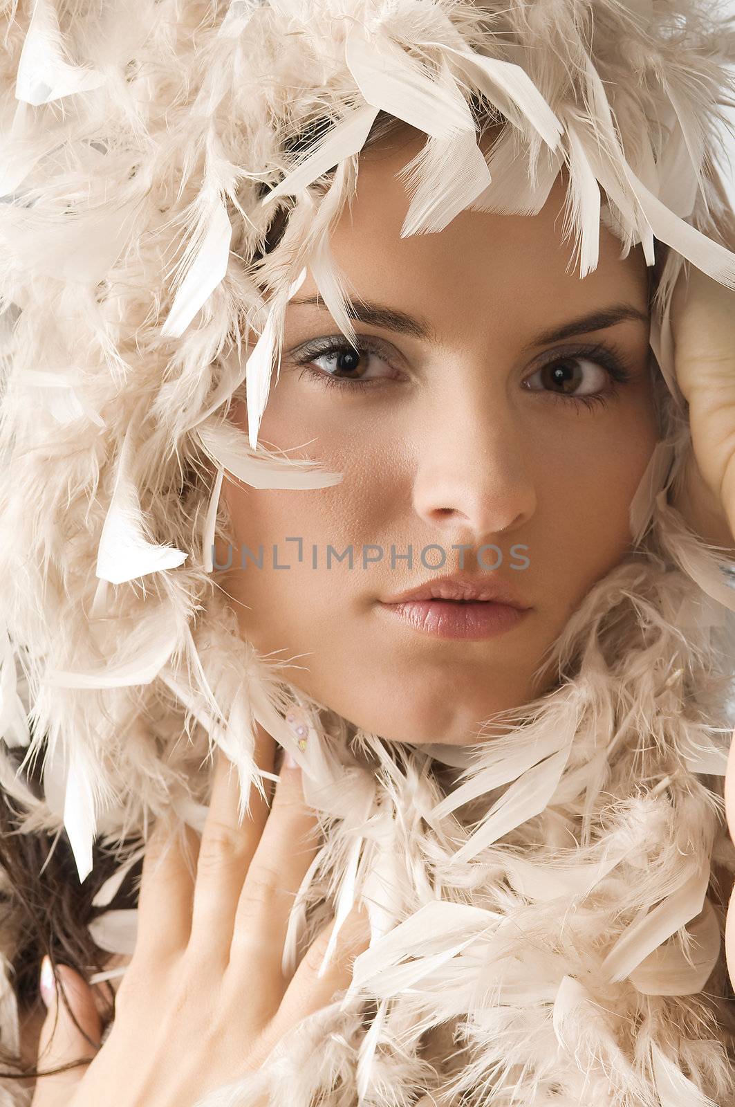 portrait of a cute young woman with feather around her face