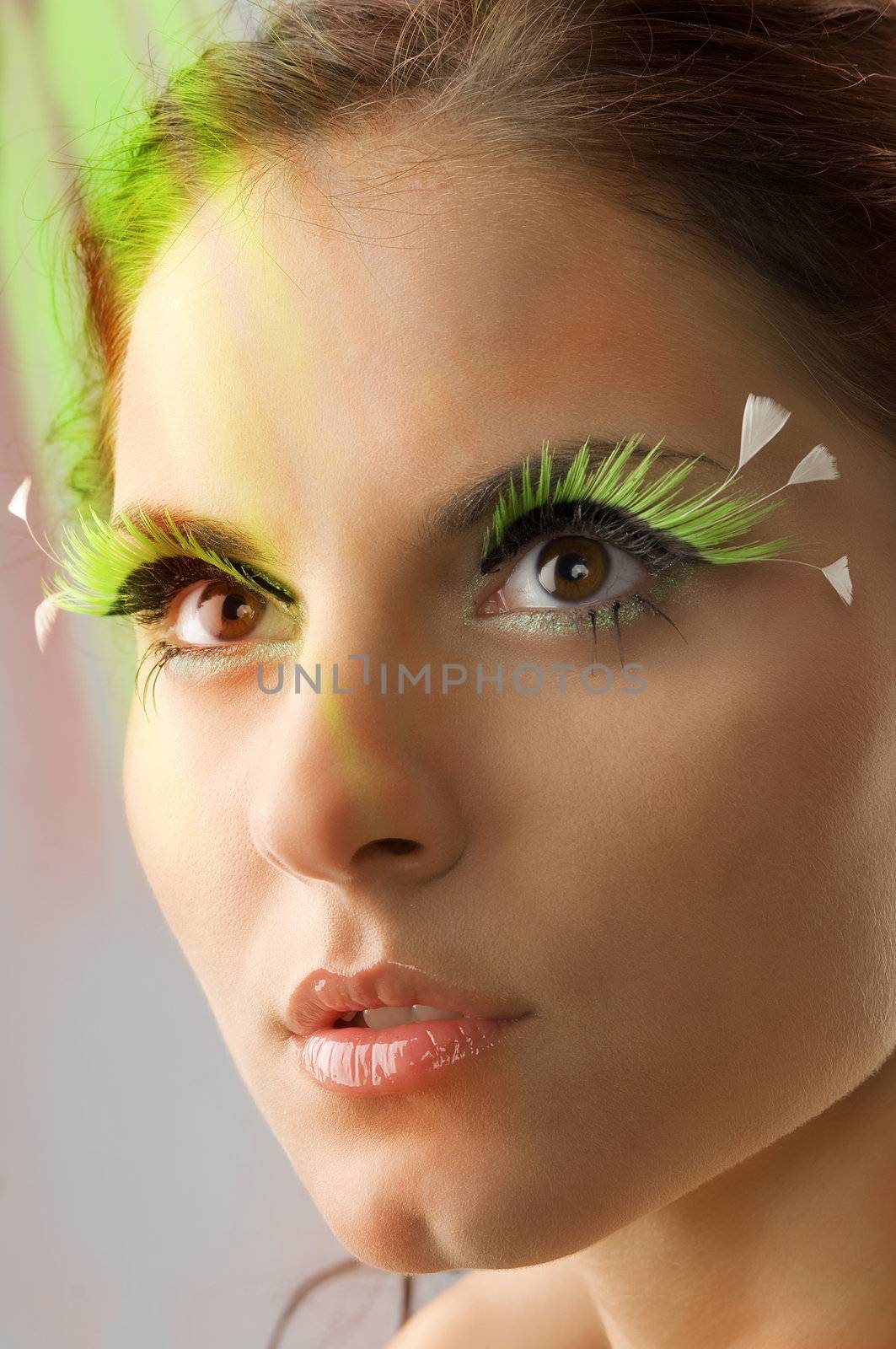 nice portrait of a young woman with artificial green eyelashes on her eyes