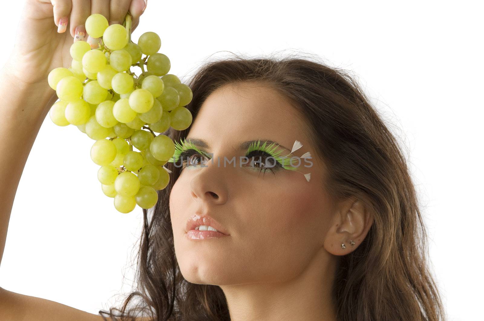 portrait of a young and sensual brunette with a green grape