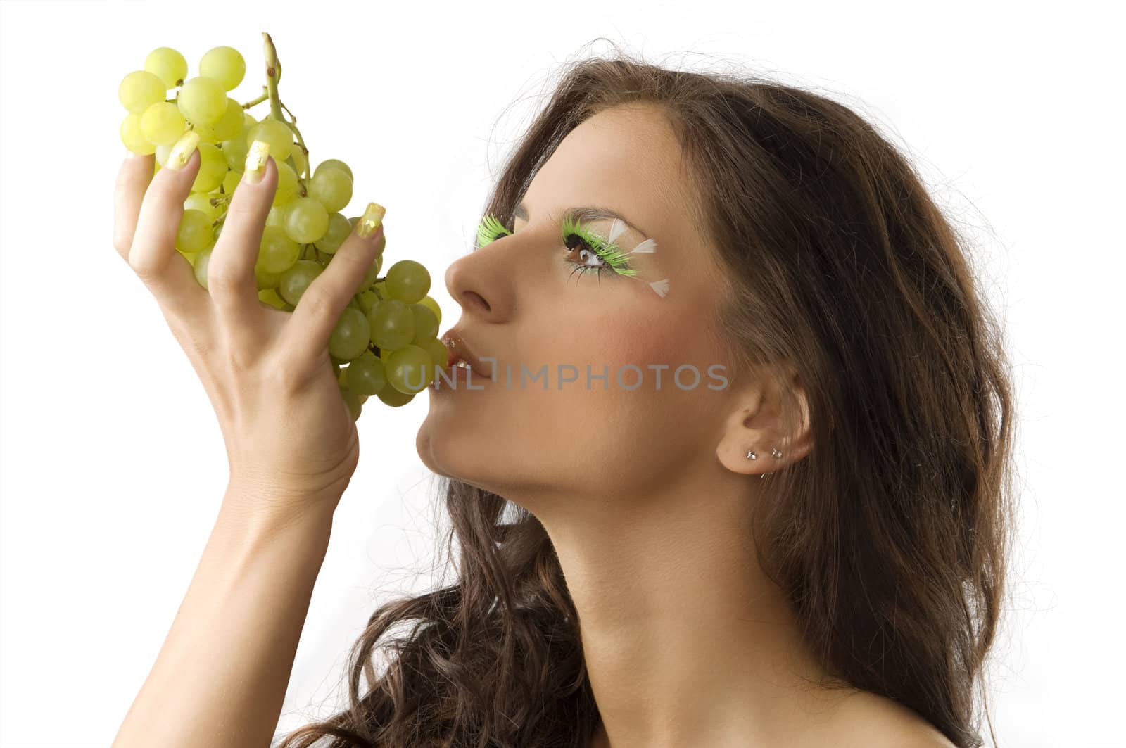 portrait of a young and sensual brunette eating green grape