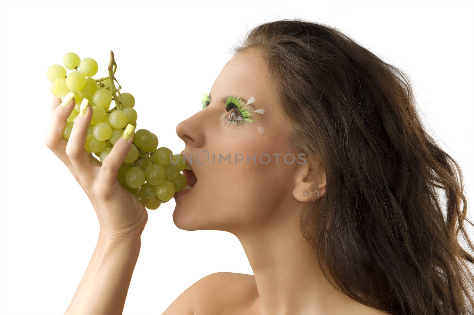 pretty brunette eating green grape and having green eyelashes