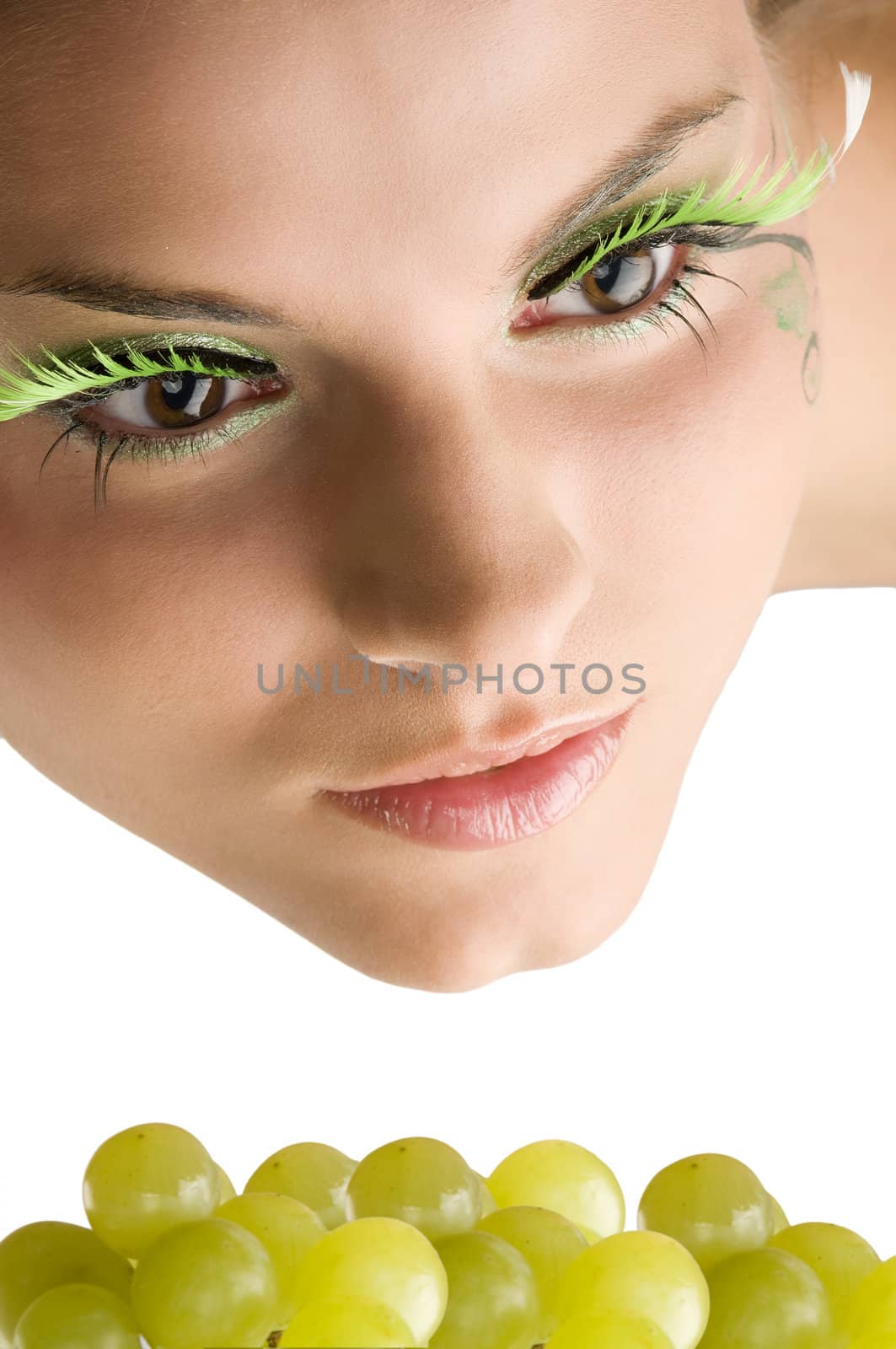 close up of a cute girl with artificial eyelashes and some green grape