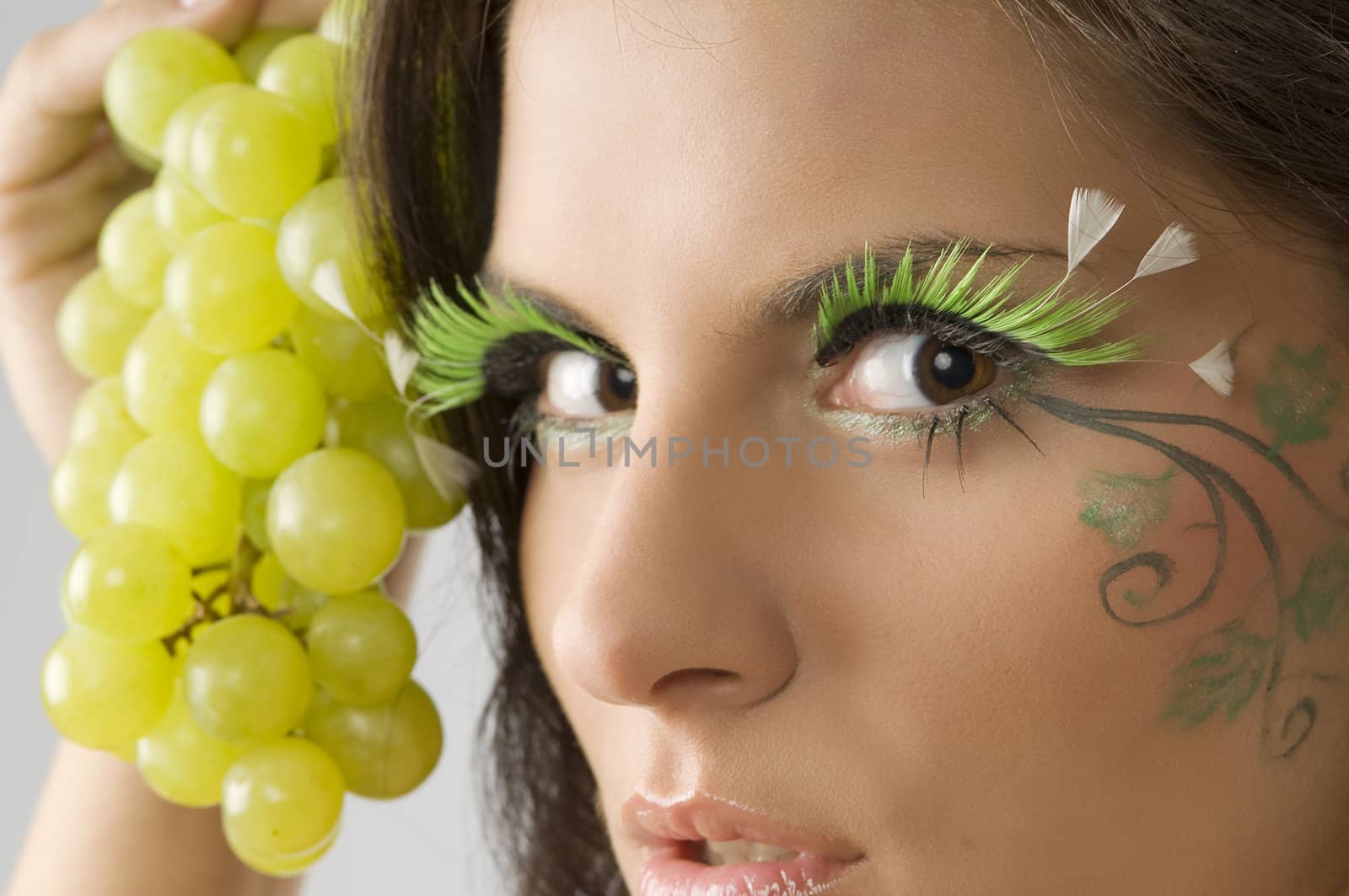 close up of the eyes of a cute brunette with artificial eyelashes and face painted