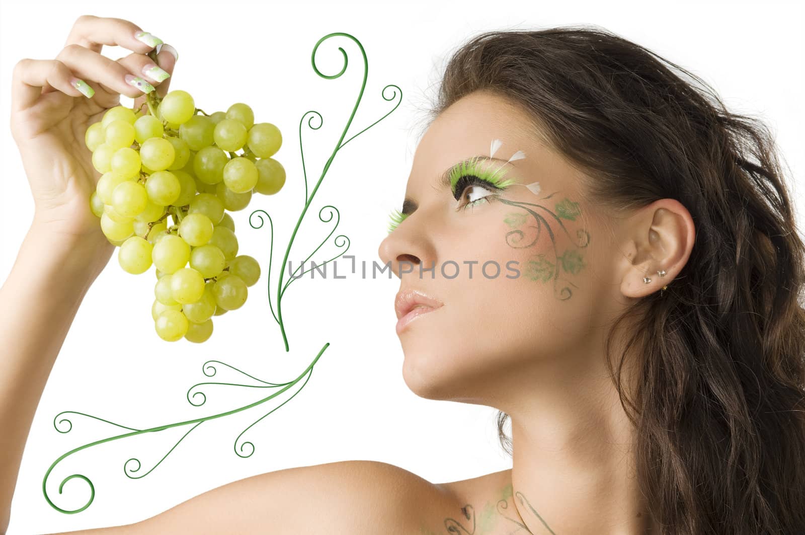 pretty girl with face painted looking at the green grape kept in her hand