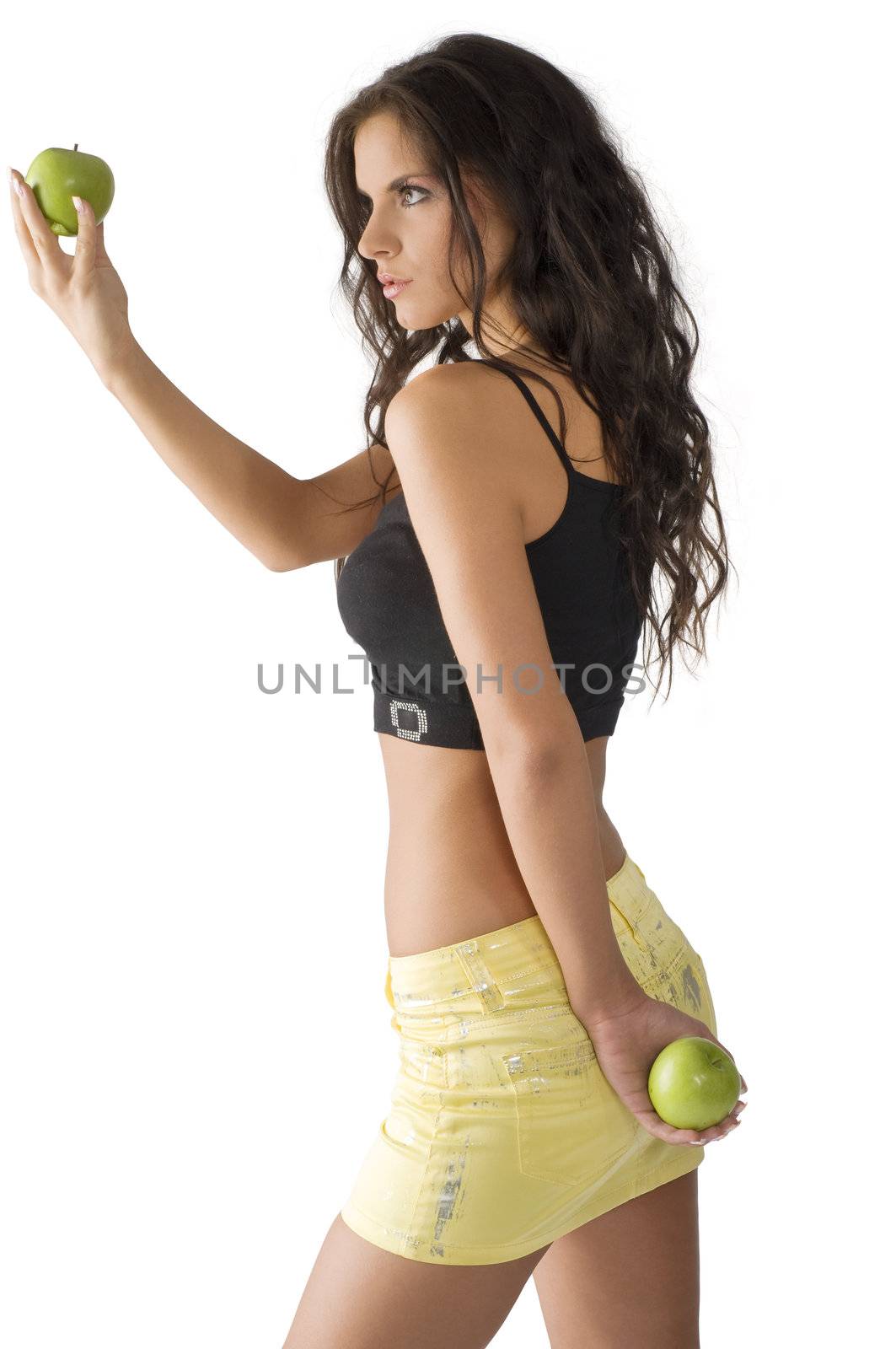 cute young brunette looking at a green apple with big interest