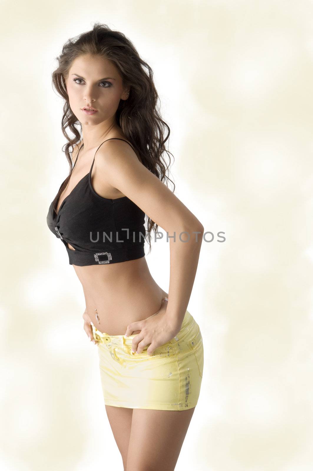 sensual brunette with short yellow skirt and a black top in model pose