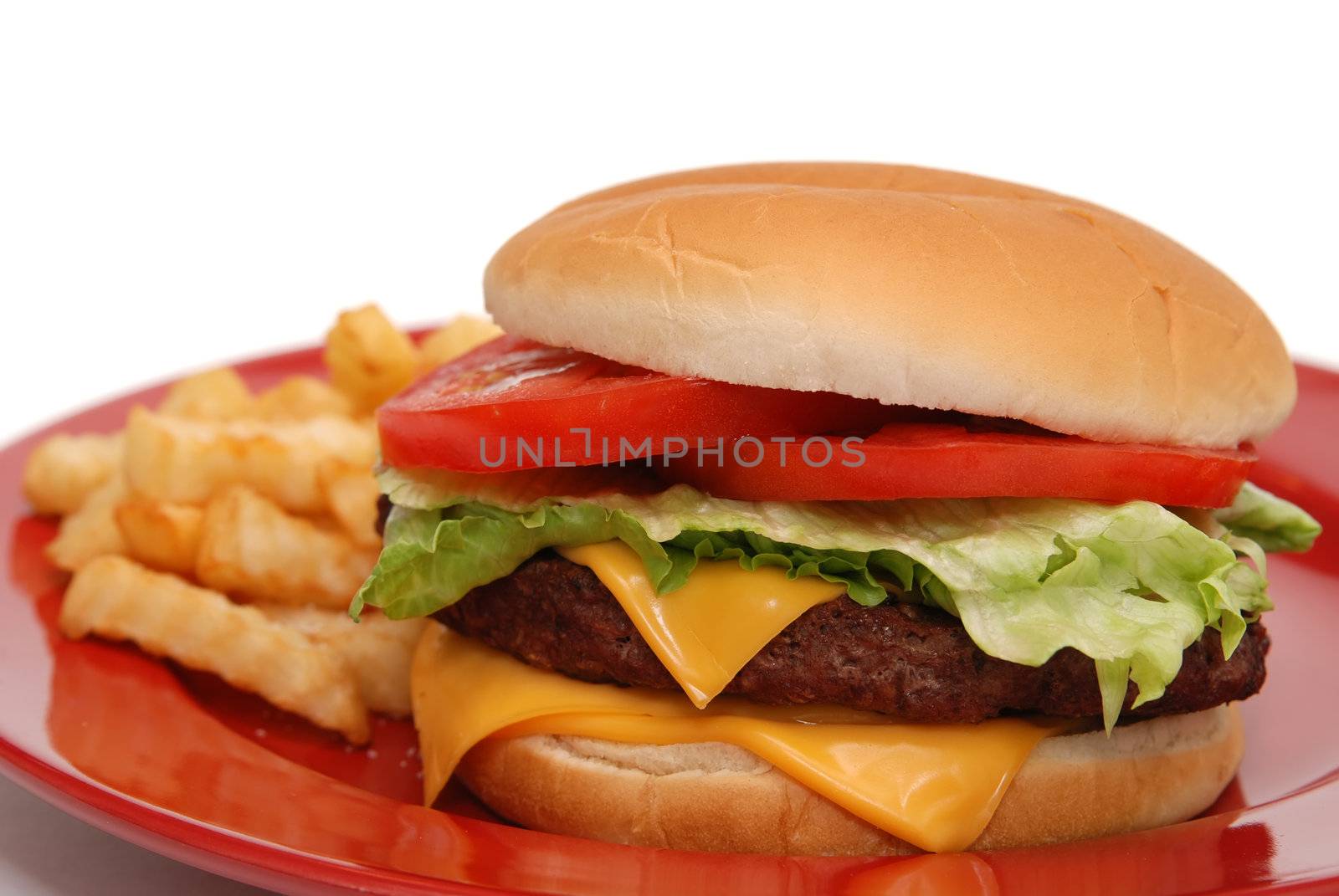Cheeseburger and french fries on red plate.
