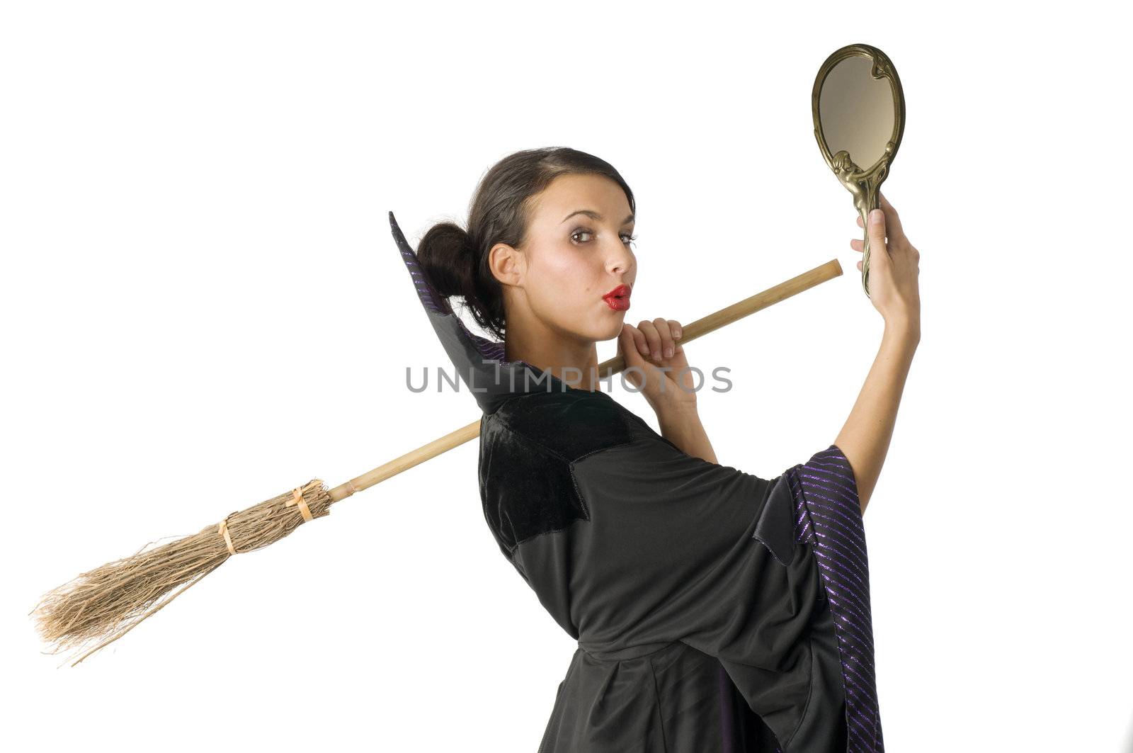 beautiful witch making funny face and keeping broom on shoulder