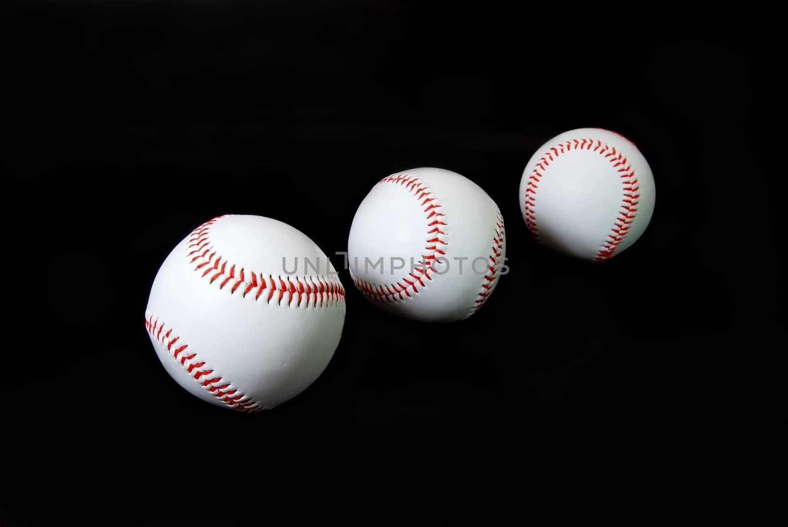 Three baseballs isolated on black background.