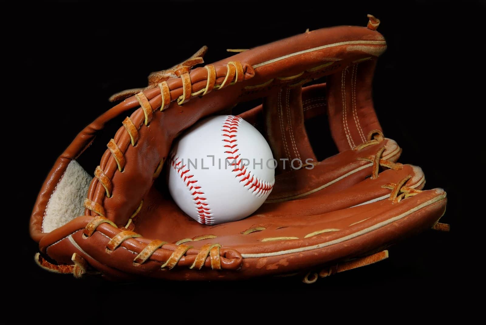 Baseball in glove isolated on black background.