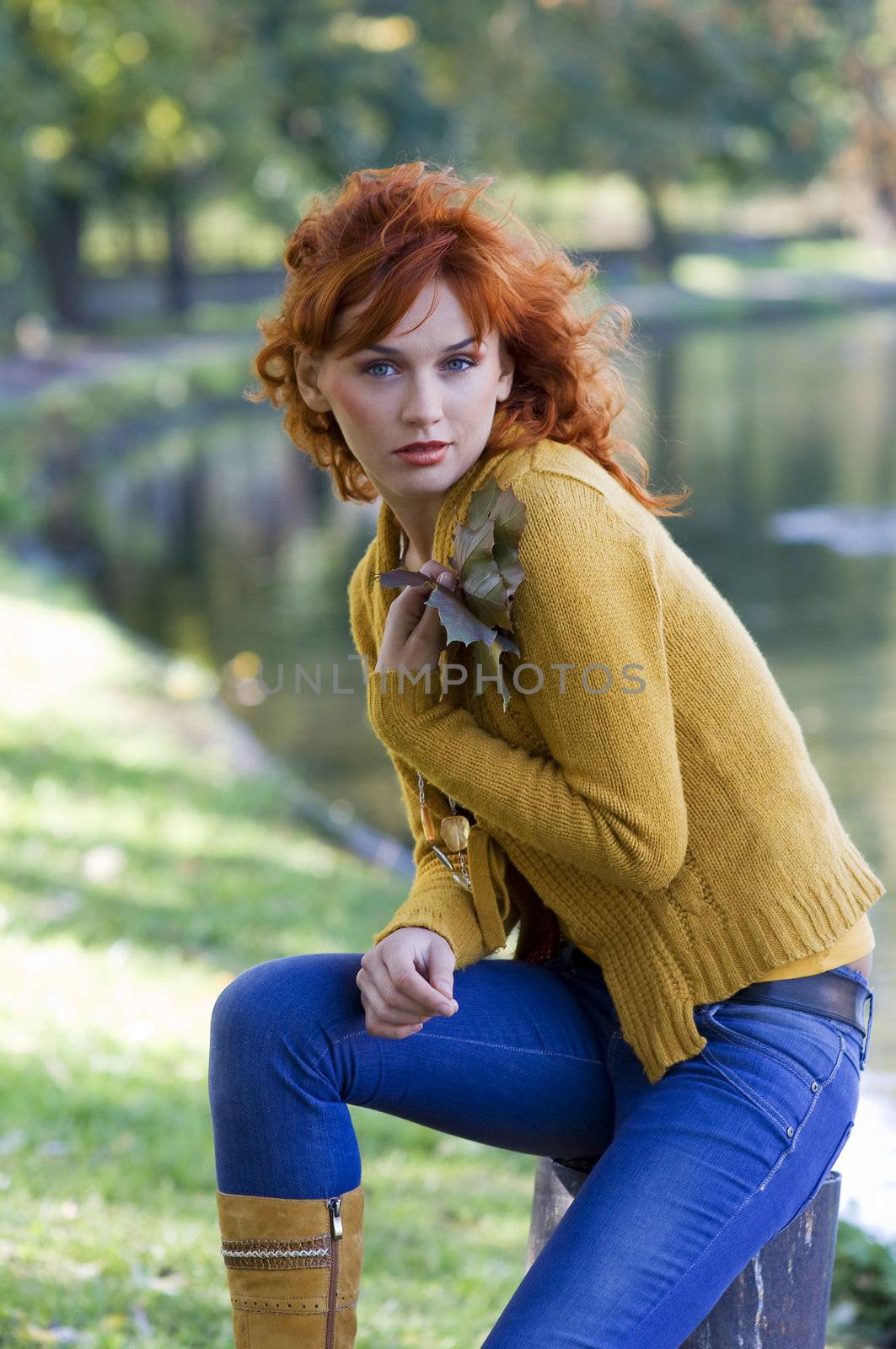 nice woman with red hair near the river in autumn season