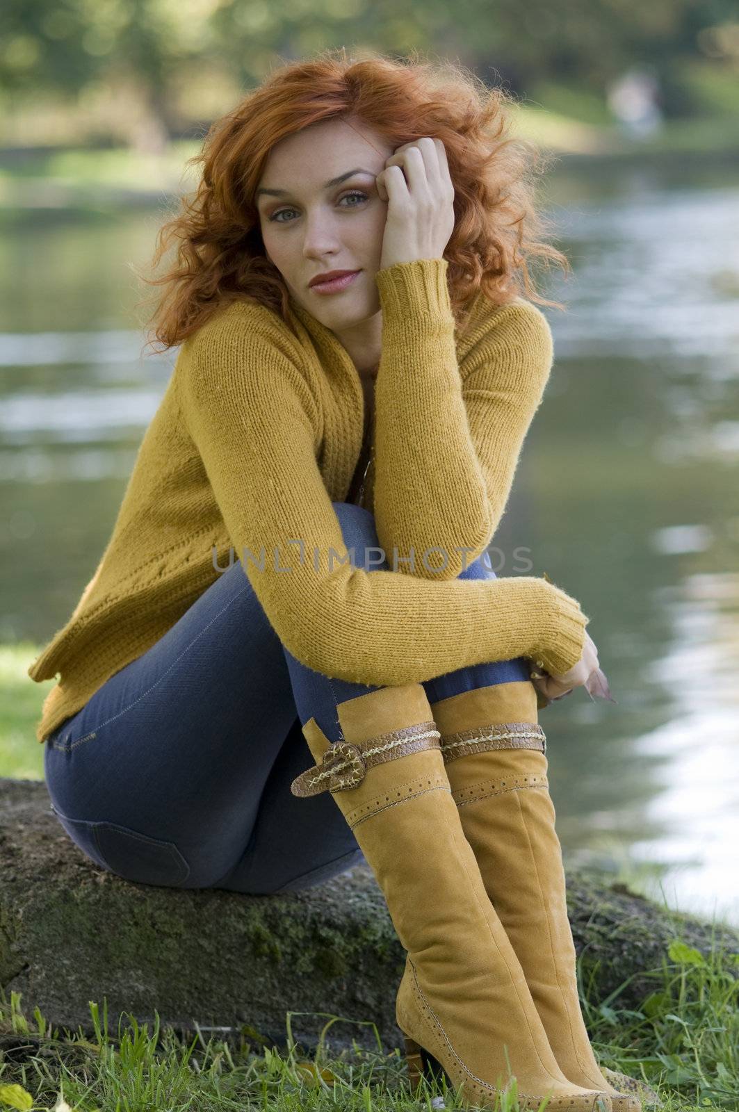 pretty and young woman posing near a river in fall season