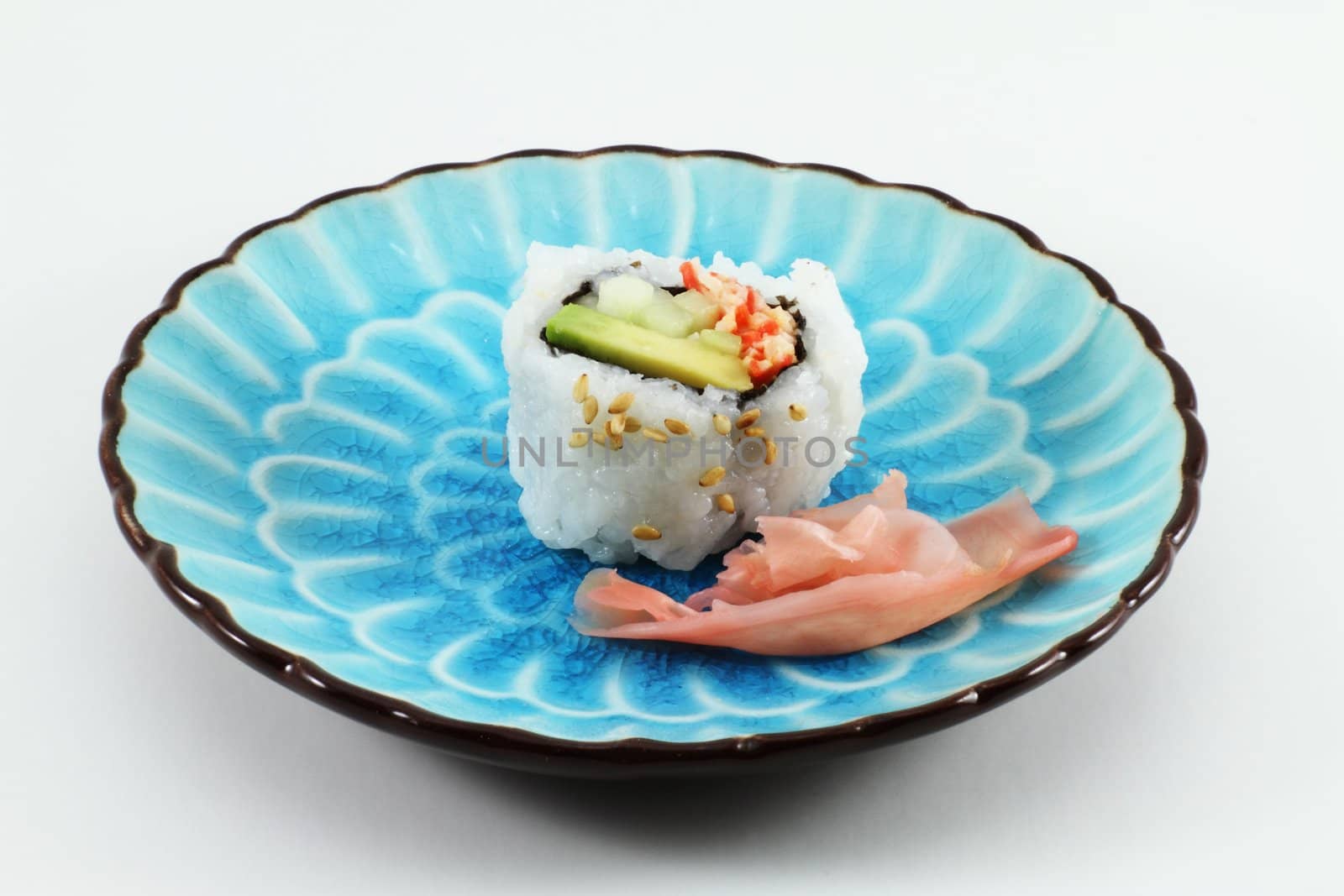 Sushi and ginger root on a blue dish.
