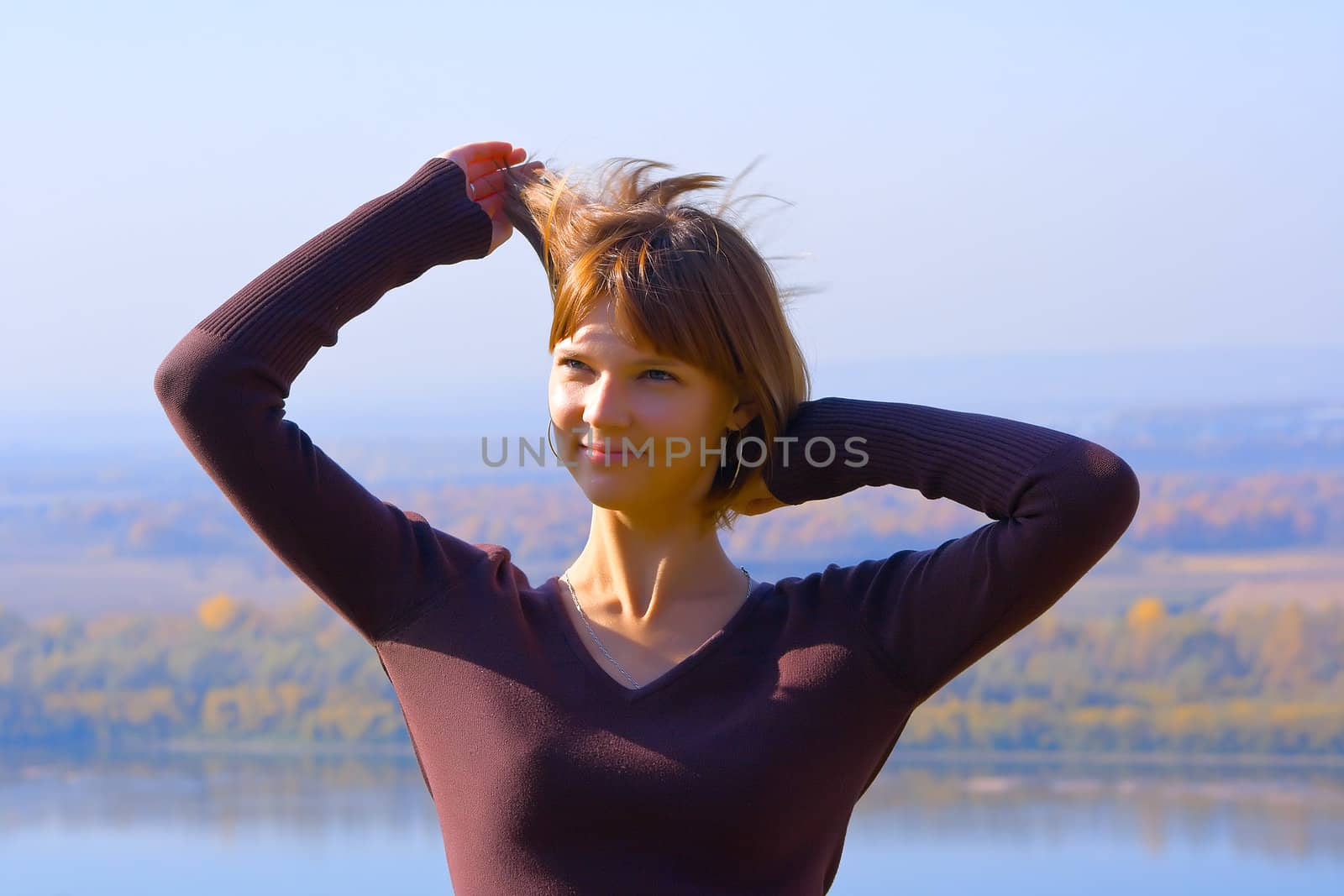 Portrait of the beautiful young girl against blue sky