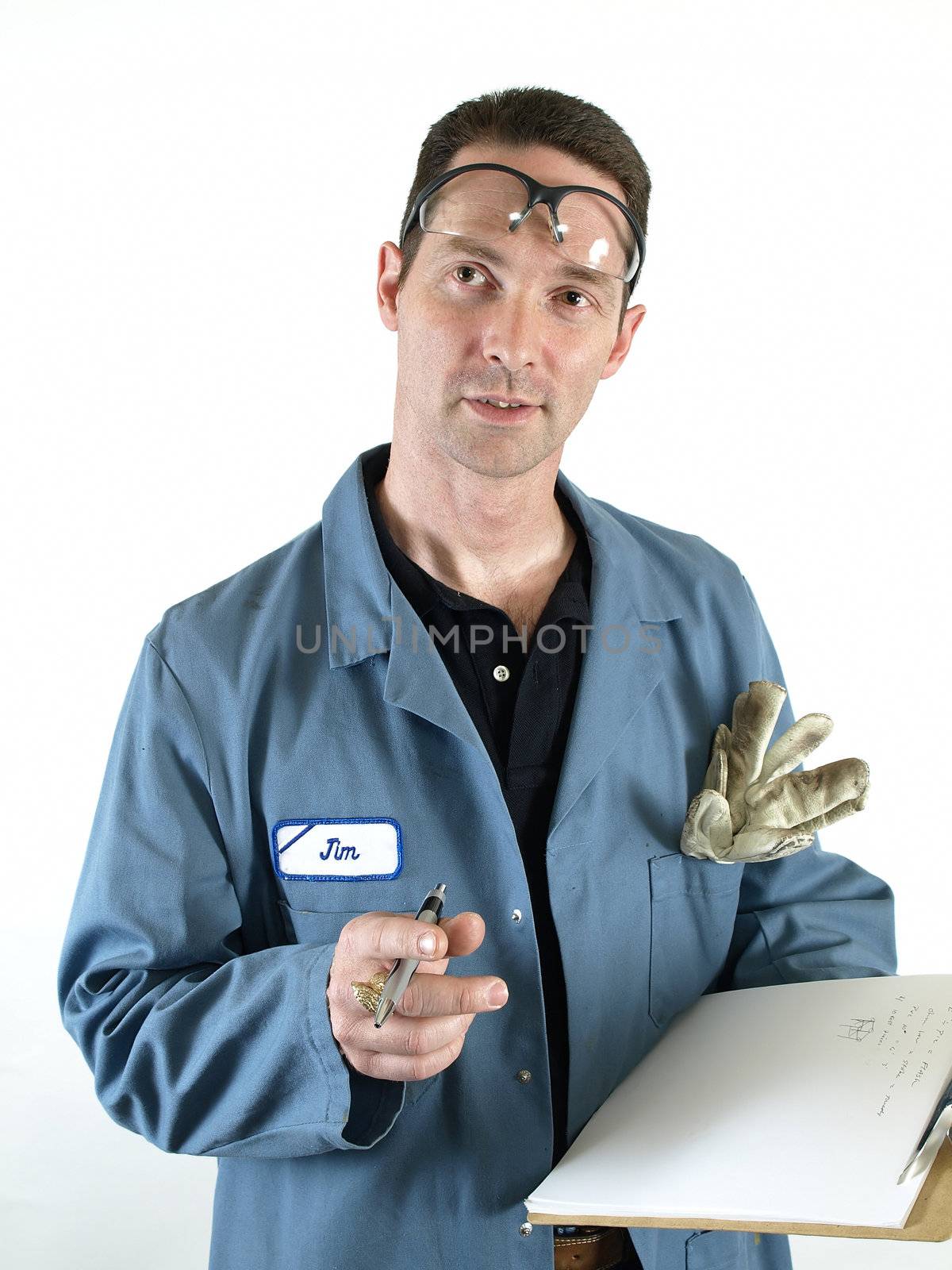 A male in a blue lab coat with a clip board stops writing to ask a question.